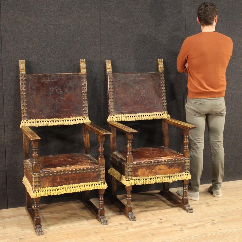 Pair of Italian armchairs from the mid-20th century. Furniture in carved wood and covered in leather in fabulous patina with decorations in gilded and chiseled wood. Pair of living room or studio thrones of great visual impact and discreet comfort,