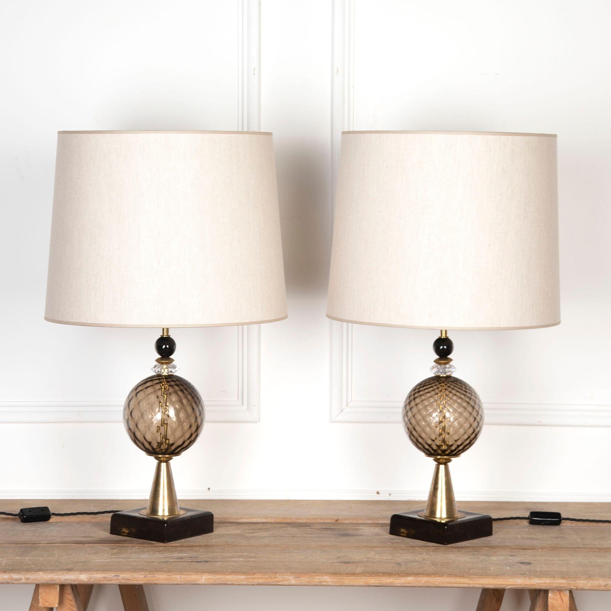 Pair of beautiful late 20th Century Italian Murano table lamps. 
Mid-Century in style, in smoked glass and brass with beige lampshades.