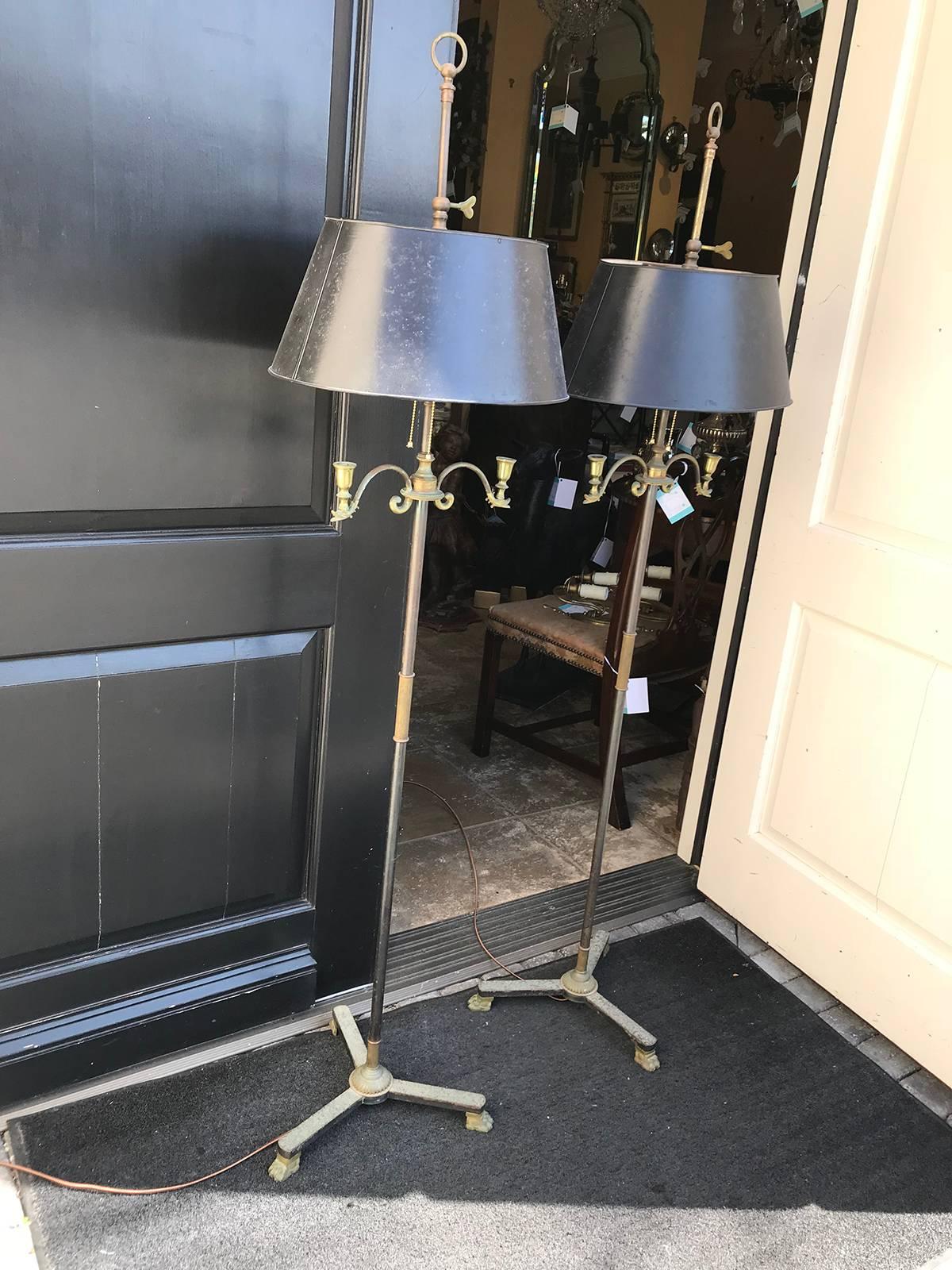 Pair of 20th century neoclassical iron and brass floor lamps with tole shades, swan heads, paw feet.