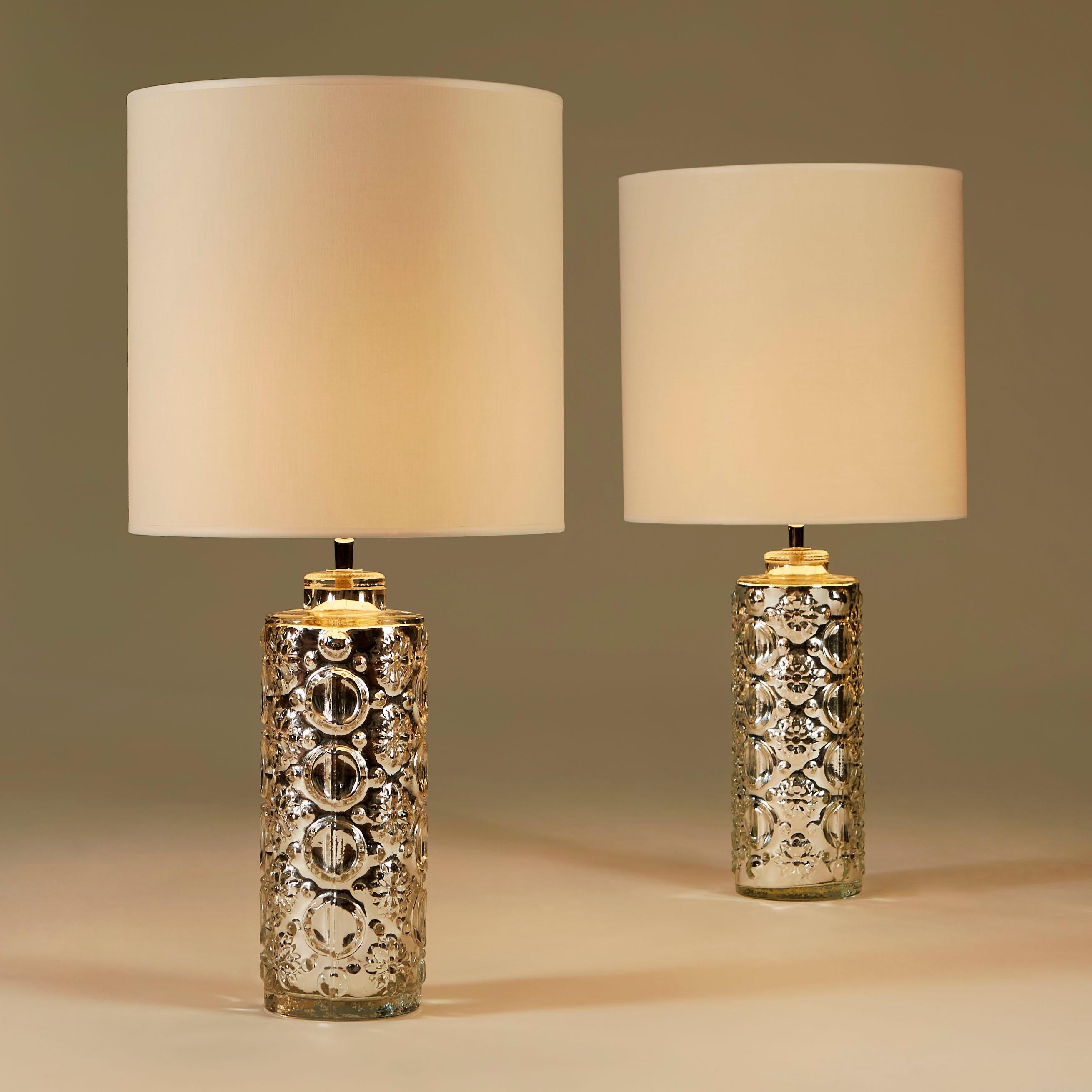 Glamorous pair of decorative silver table lamps by Swedish glasswork company Orrefors. Custom lampshades included.

Measures: Height excluding shade 45cm.
