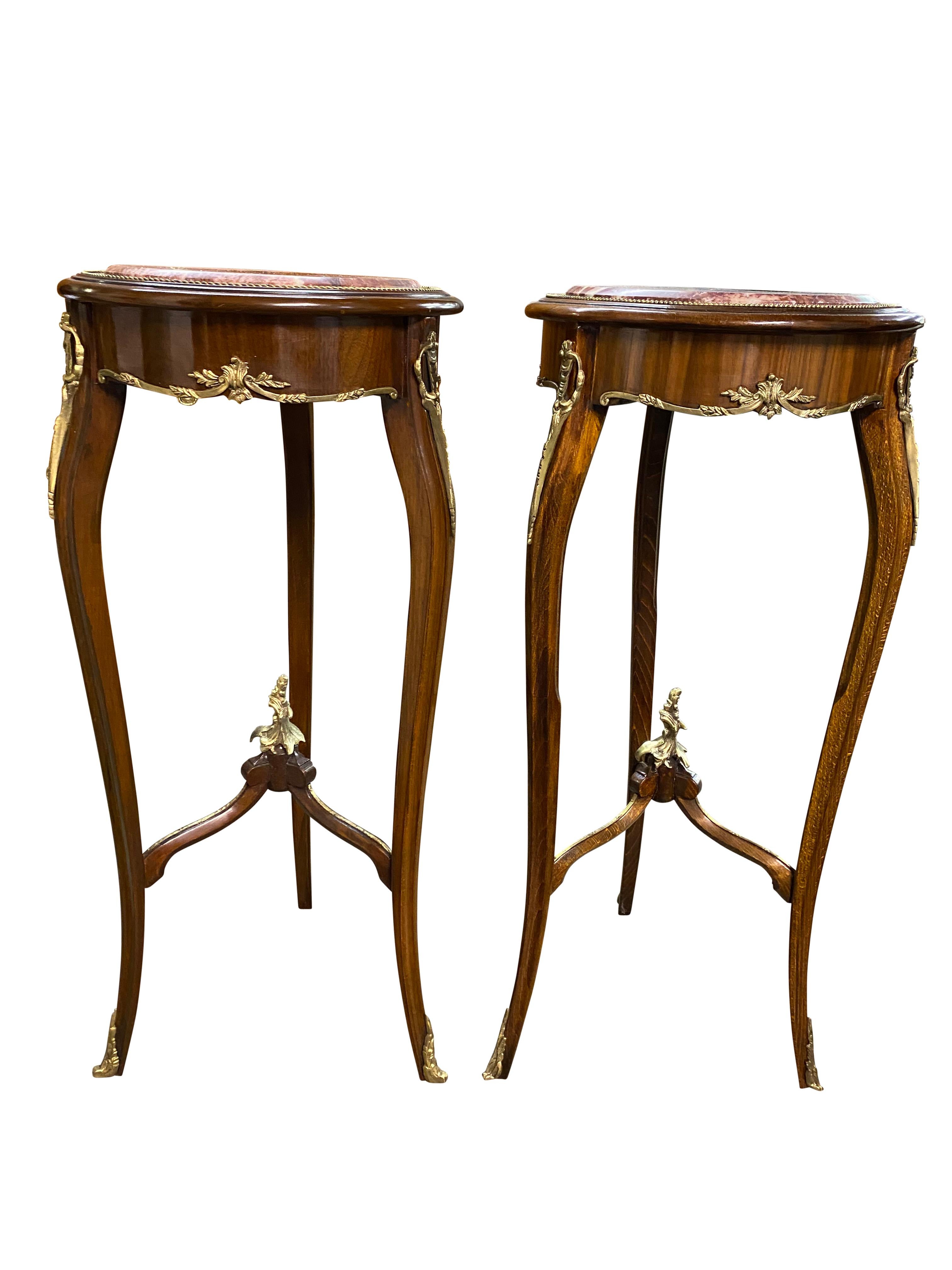 A stunning pair of 20th century oval marble top Empire style side tables. A gorgeous and elegant design perfect for modern interiors.