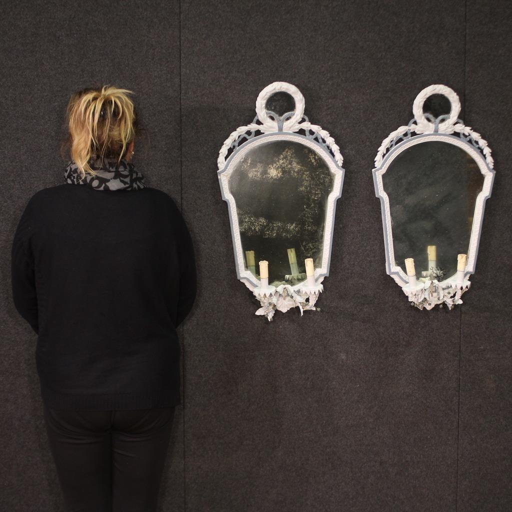 Paire de miroirs / appliques italiens du milieu du 20e siècle. Meubles finement sculptés de style Louis XVI, peints au cours du XXe siècle. Appliques à deux lumières avec support d'origine en métal travaillé et peint, avec système électrique à
