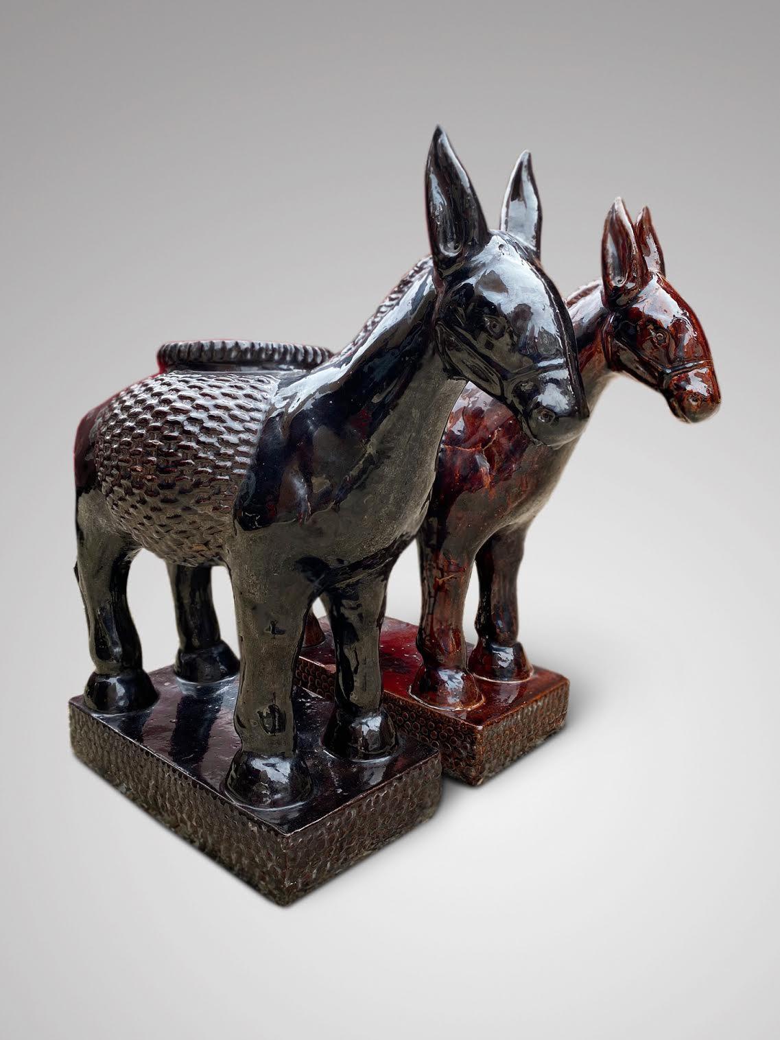 A pair of very decorative 20th century brown and black glazed pottery jardinieres or plant stands modelled as donkeys. Can be sold separately.

The dimensions are:
Height: 73cm (28.7in)
Width: 72cm (28.3in)
Depth: 33cm (13.0in)

In good antique