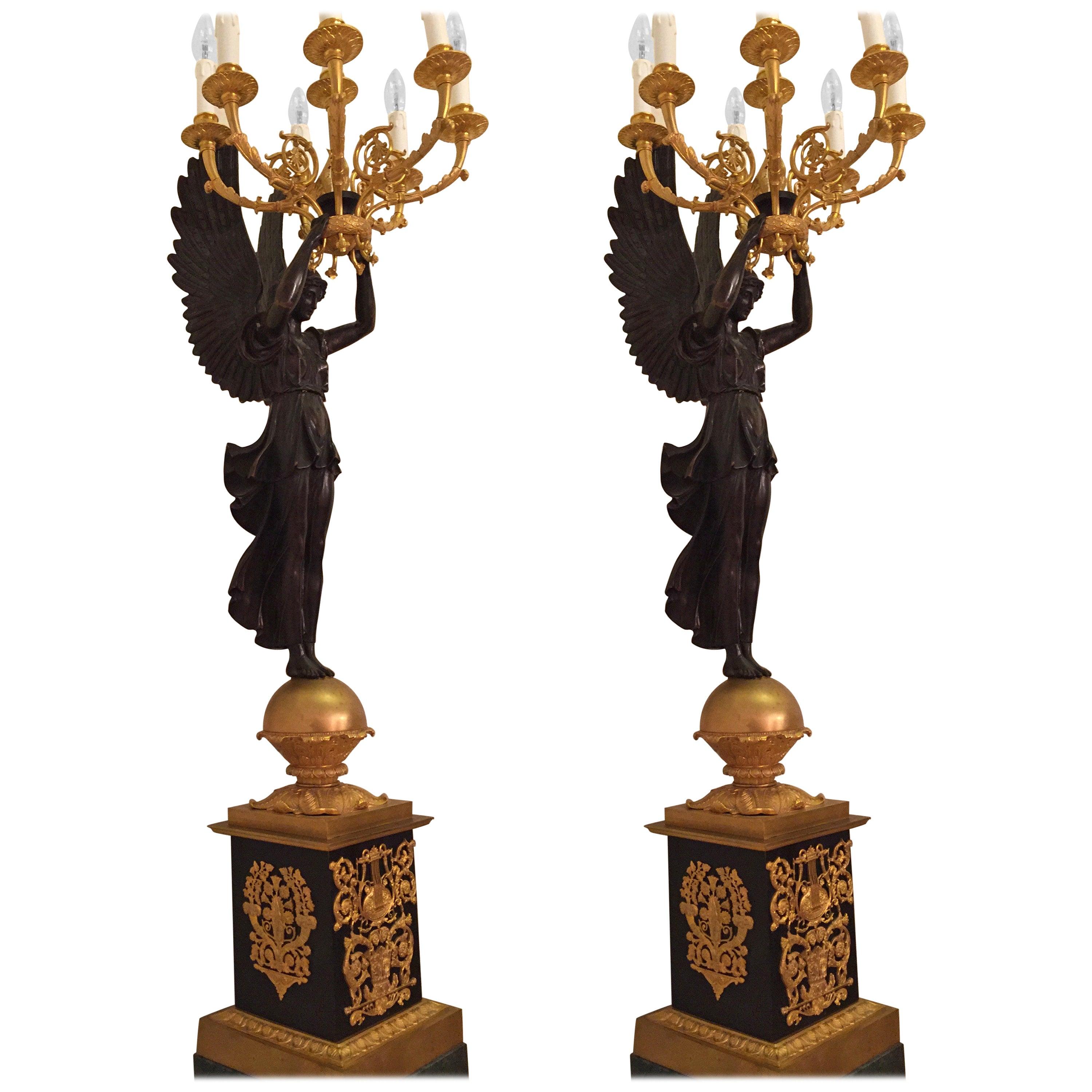 A pair of Princely candelabra.
Exceptionally fine engraved and moulded bronze. Fully moulded
Designed figurines (Victoria). Overhead and hand held torch formed
shaft with 12 fully horn-style sweeping light arms. This model belongs
to the