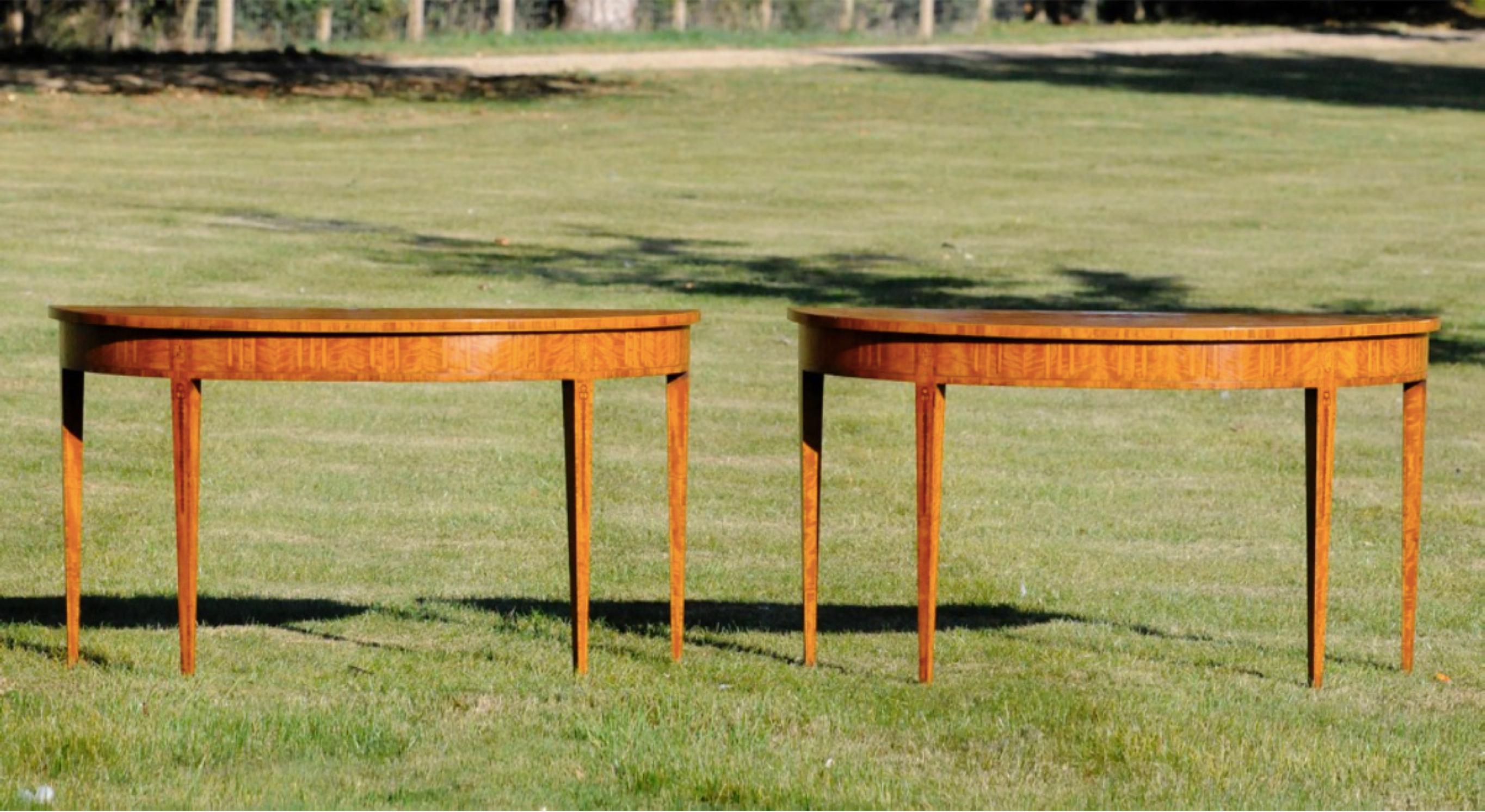 A very good pair of 20th century satinwood demilune console tables in the Adam style. 
With profuse inlay of tazza, griffins, fans and swags to the tops; flutes, paterae and festoons to the frieze and square section tapering legs.

Provenance: