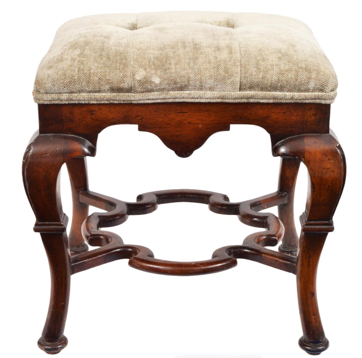 This pair of Spanish colonial style benches or ottomans feature a great sculptural form with robust cabriole legs joined by beautiful carved and shaped stretchers centering an inner partly circular space. The are upholstered and covered with a