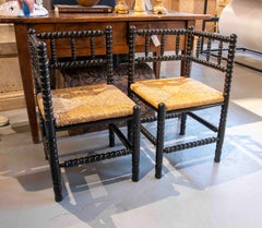 Pareja de sillones torneados españoles del siglo XX con asientos de junco