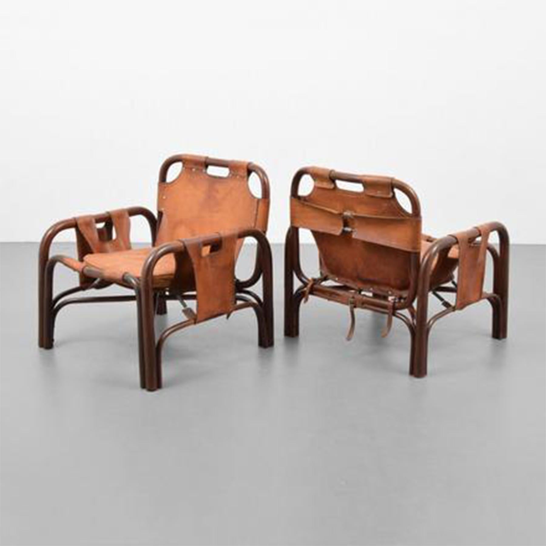 Beautiful pair of 20th century Italian lounge chairs designed in the manner of Vittorio Bonacina. Stitched elegant leather strap construction in the midst of an open wood framework.