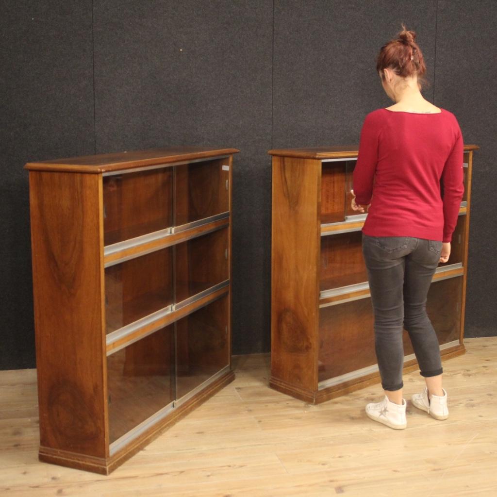 Paire de bibliothèques italiennes des années 60 et 70. Meuble en bois de noyer équipé de portes coulissantes en verre sur un rail métallique. Vitrines d'excellente capacité et service avec verre d'origine sans cassure ni ébréchure (voir photo).