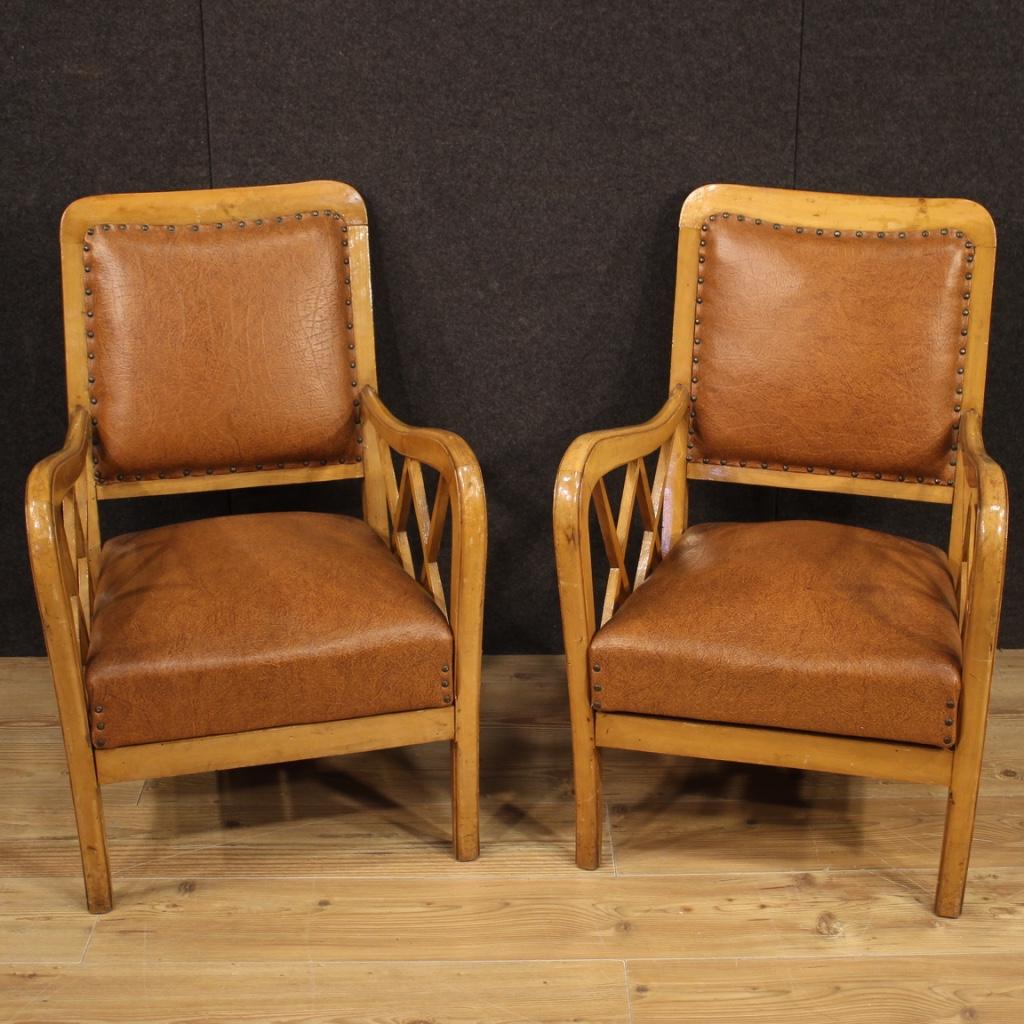 Pair of Italian design armchairs from the 1960s-1970s. Furniture carved in walnut and fruitwood of particular line and pleasant decor. Armchairs with removable seat covered in faux leather with some small signs of wear. Fixed backrest also covered