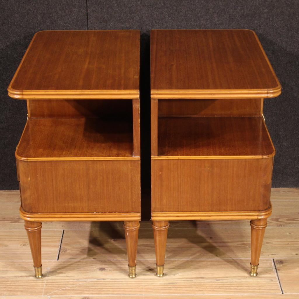 Pair of mid-20th century Italian bedside tables. Italian design furniture carved and veneered in mahogany and beech wood with chiseled and gilded metal decorations. Bedside tables equipped with a door and two drawers of reasonable capacity. Night
