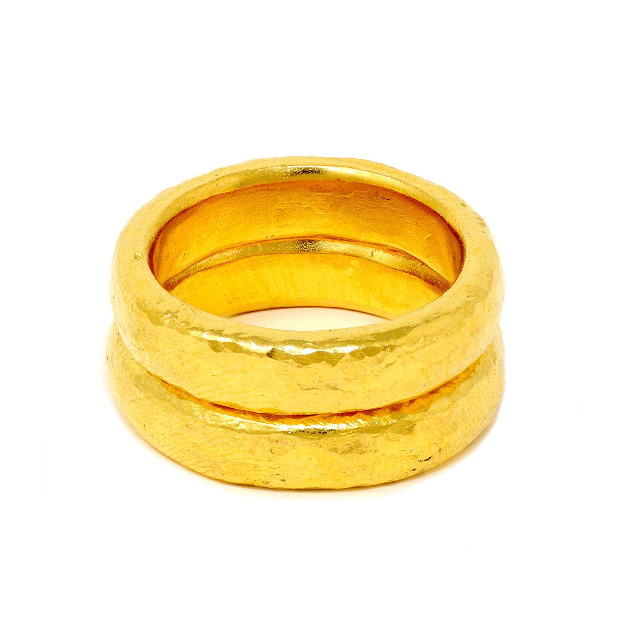 A pair of handmade 24 karat gold band rings by Rosaria Varra. The pure gold of 24k make these bands substantially hefty in weight  of around 14 grams depending  on finger size. These rings can be custom made to order. This set of bands are 8 ¾. 