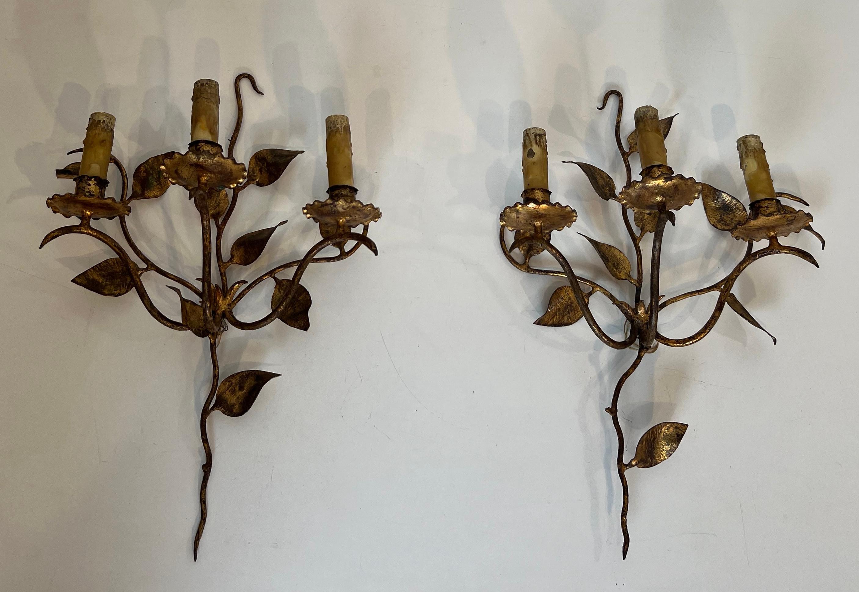 Cette paire d'appliques murales à 3 lumières est en métal doré. Ils sont décorés de feuilles. Il s'agit d'un ouvrage français. Circa 1970