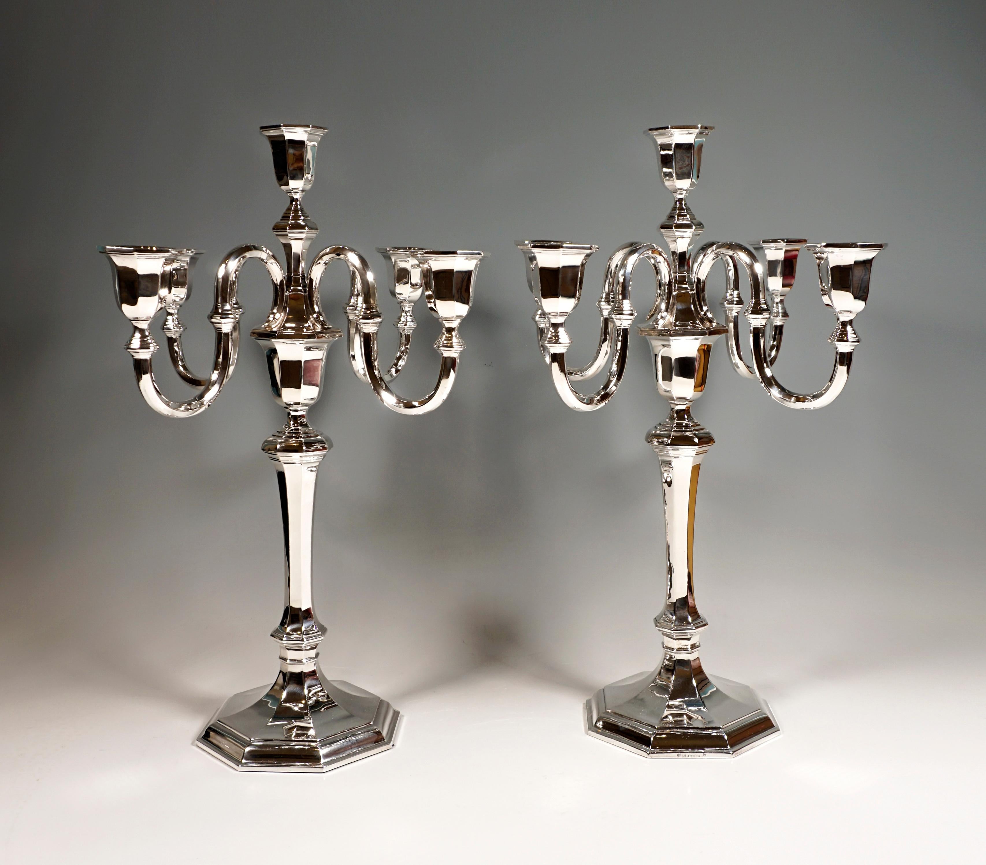 Two five-light candelabras of simple, austere elegance on an octagonal, stepped base, raised in the middle and ending in a shaft with an octagonal cross-section, octagonal beaded rings at the beginning and end of the slightly widening shaft,