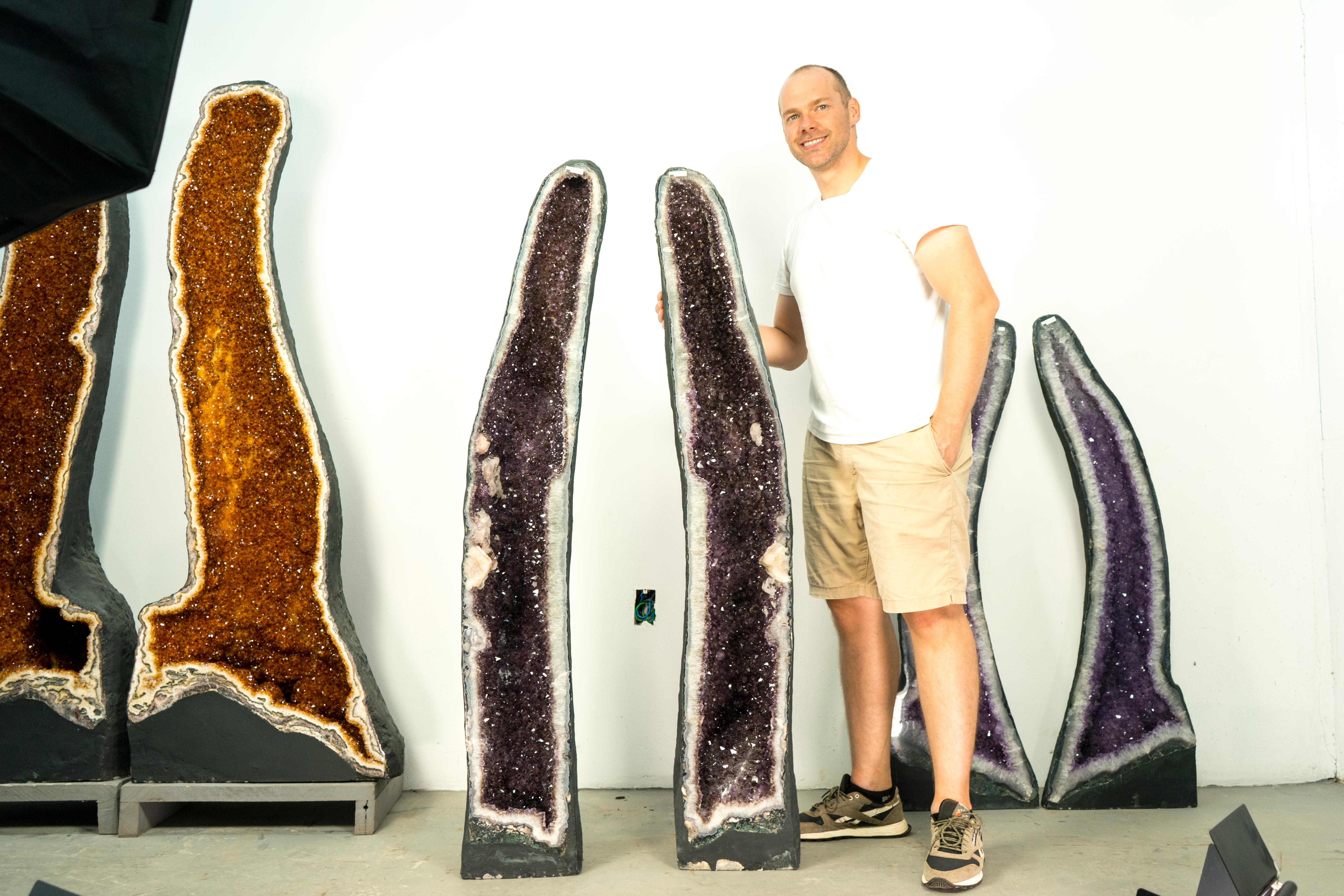 Superb Tall Pair of Amethyst Geodes with Calcite and Goethite Inclusions and Shiny Lavender Amethyst Druzy

▫️ Description

An extraordinary pair of book-matched amethyst geodes stand tall in an upright formation, perfectly displaying their shiny