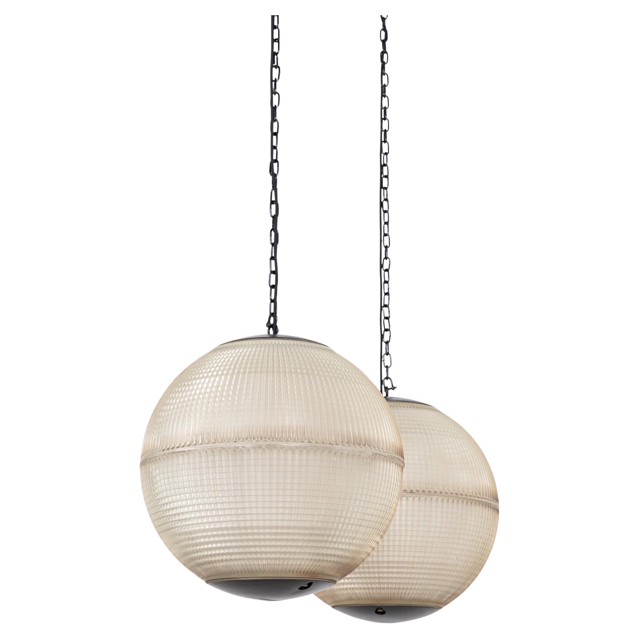 A pair of large spherical Holophane Parisian glass street lights, made in France. c.1960

Bearing the larger 50cm diameter, a fabulous pair of statement pendant lights - formerly pole mounted street lights from Paris. Unusually with a metal top cap,