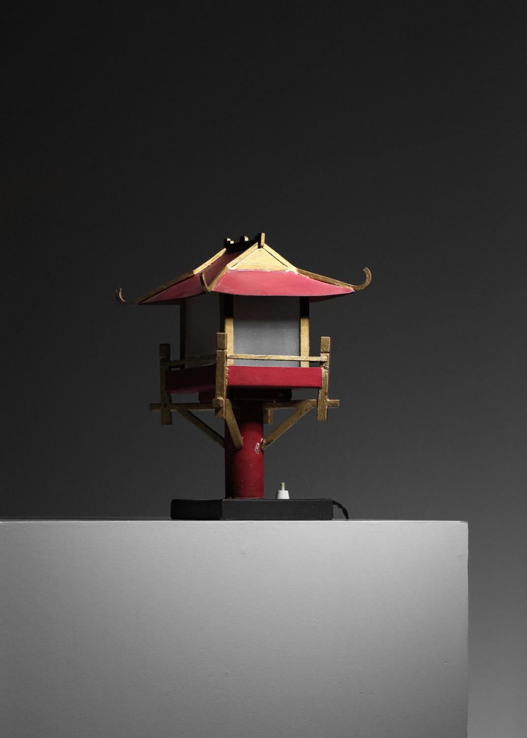 Paire de lampes de table très originales des années 50 représentant de petites pagodes chinoises. Structure métallique peinte en rouge, or et noir (peinture d'origine). Diffuseurs en verre dépoli. Lampes très décoratives, en bel état vintage avec