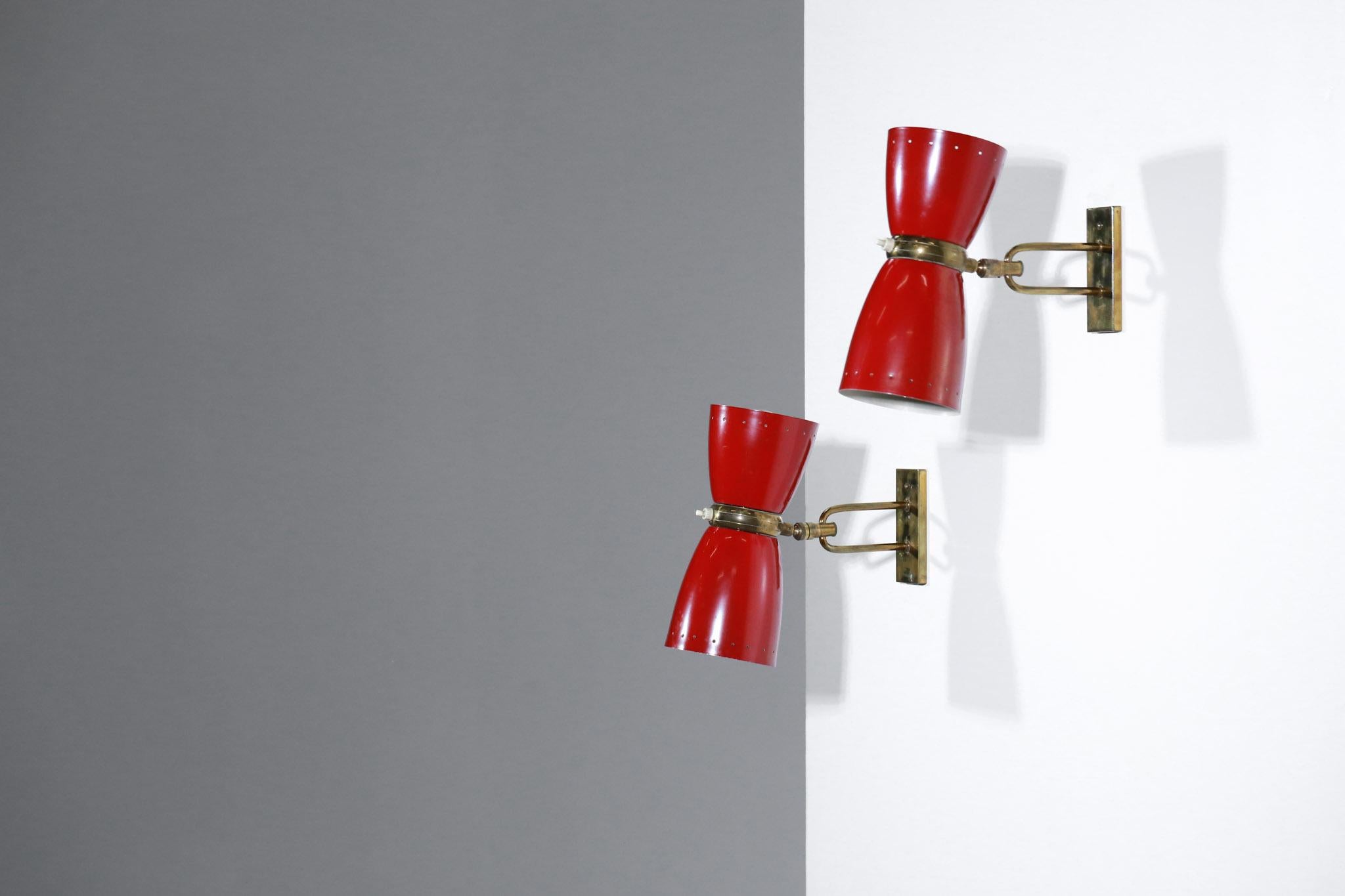 Pair of 1950s swivel wall lights in the style of the French designer Jean Boris Lacroix.
Solid brass structure and red lacquered perforated metal shade, original paint.