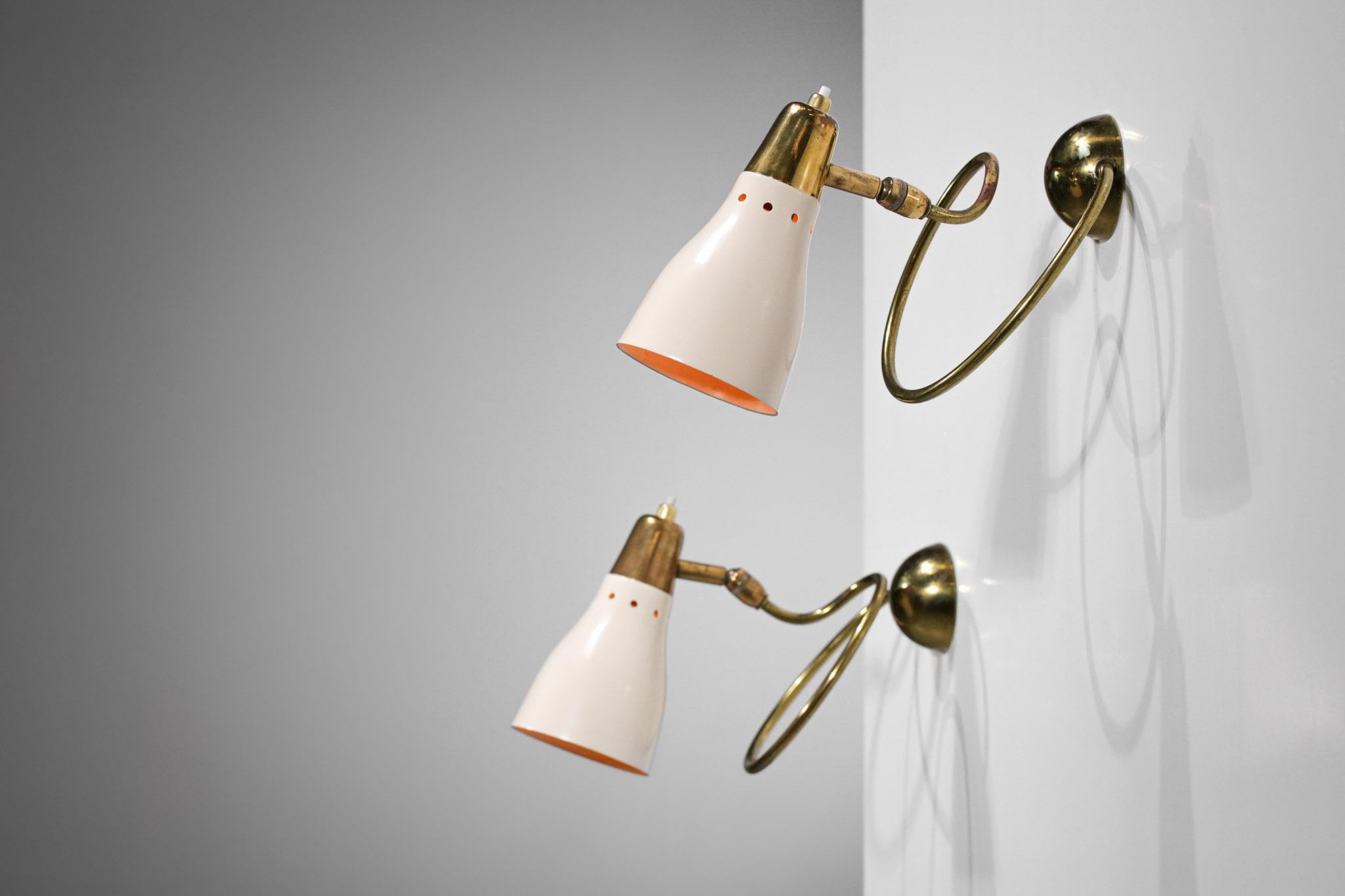 Pair of 1950's cocotte wall lights very original in the taste of Pierre Guariche's work. Structure in solid brass, lampshade in beige lacquered metal. Recommended bulbs B22, very nice patina on the brass, excellent vintage condition (see pictures).