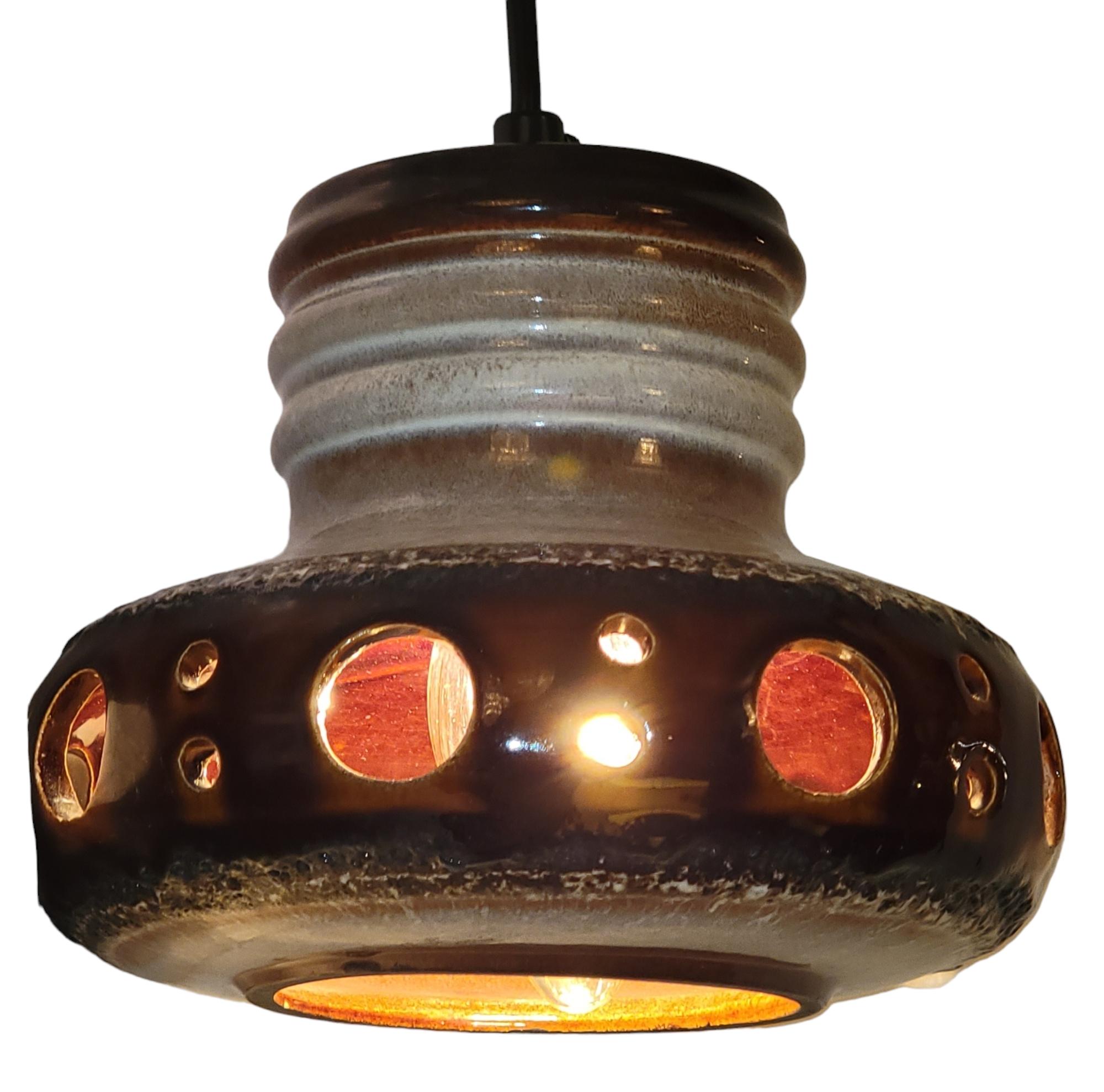 Pair of 60s German Pottery Pendant lamps. Great lighting and design. The wholes on the side of the pendant allow for light to escape un- interrupted from the bulb. Beautiful painted pottery on the exterior and beautifully painted on the interior.