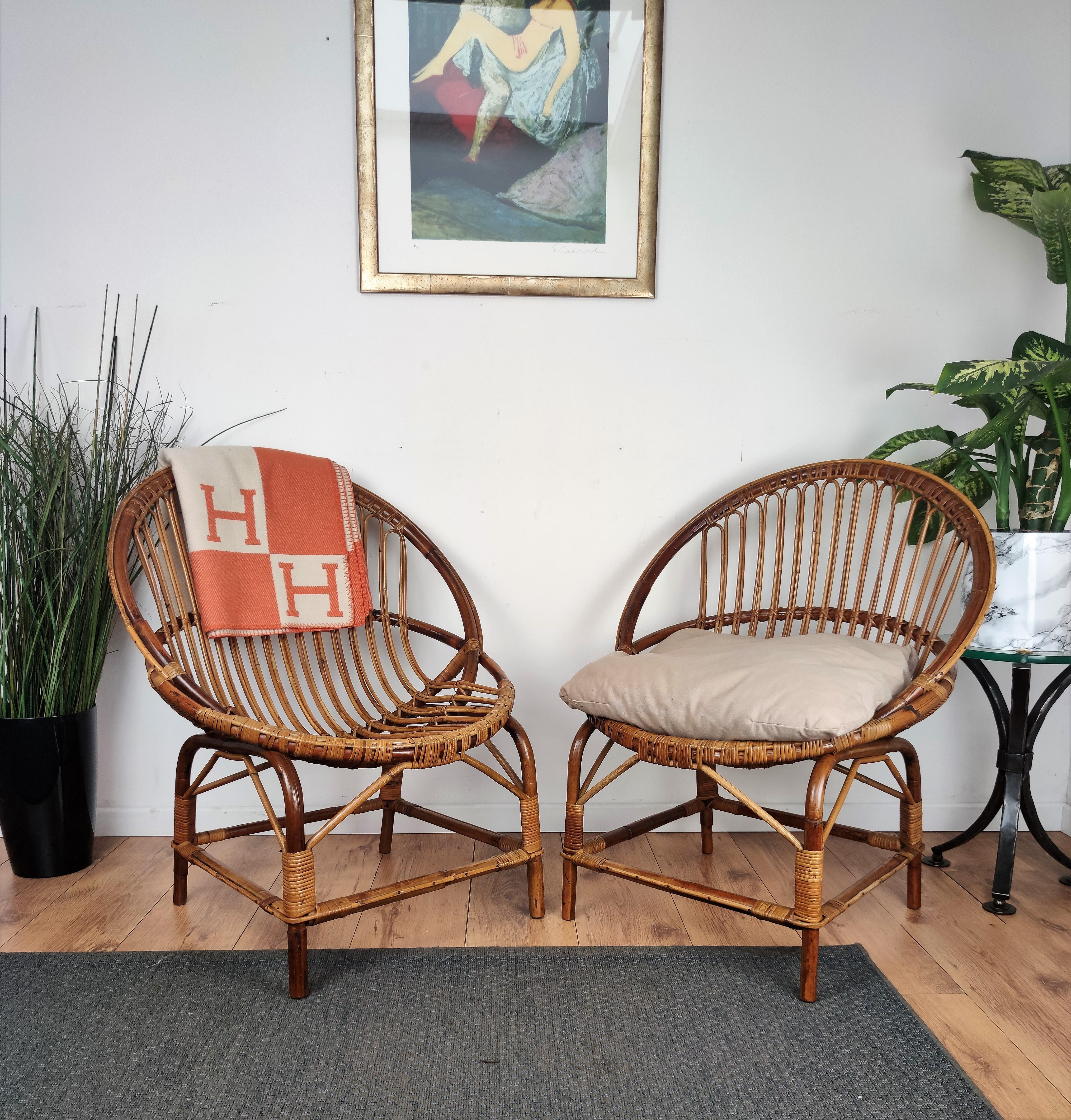 Beautiful 1960s Italian Mid-Century Modern pair of armchairs in rattan wicker bamboo with great design and shape. This charming lounge chairs are in the typical style of Franco Albini and Adrien Audoux where the organic beauty of the woven materials
