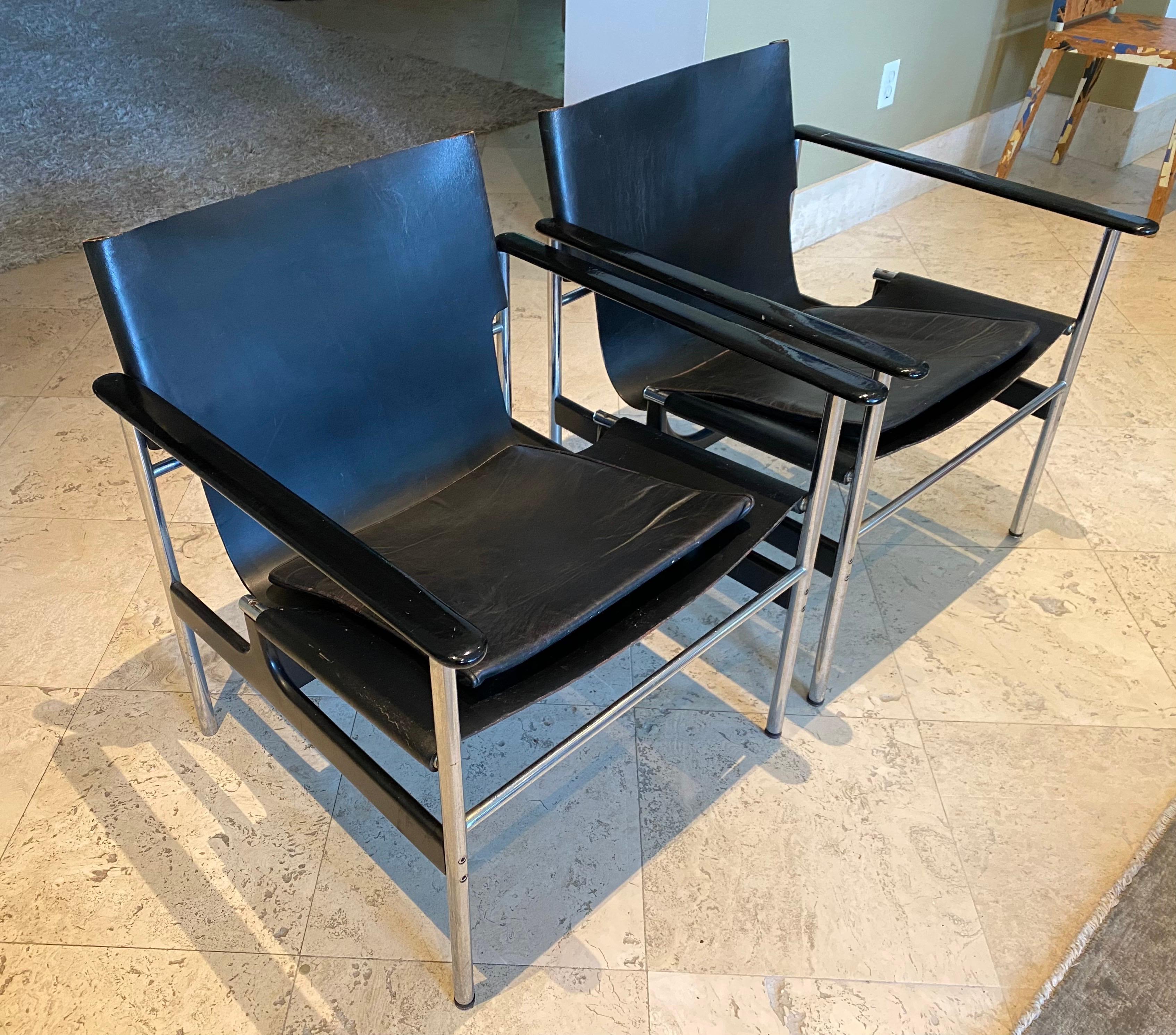A pair of early 657 armchairs by Charles Pollock for Knoll. This 1970's pair features chromed steel and wood frames with black leather seat and cushion. One additional pair available on request.