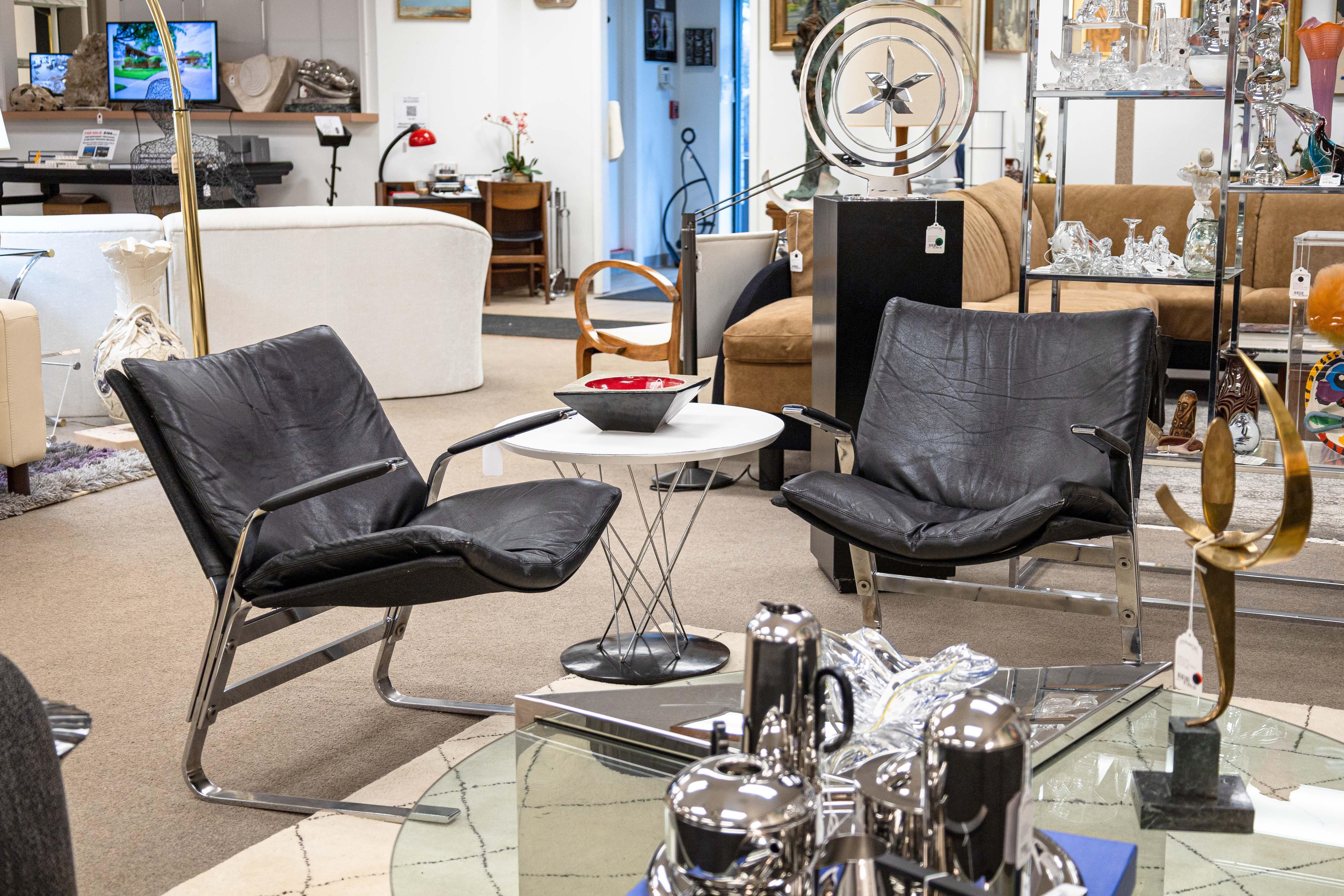 A pair of Elsa and Nordahl Solheim for Rybo Rykken & Co. Pirate lounge chairs. This chic set of 1970s armchairs have a classic black leather and chrome cantilevered construction. Each chair has a flat bar chrome frame, with a layered design