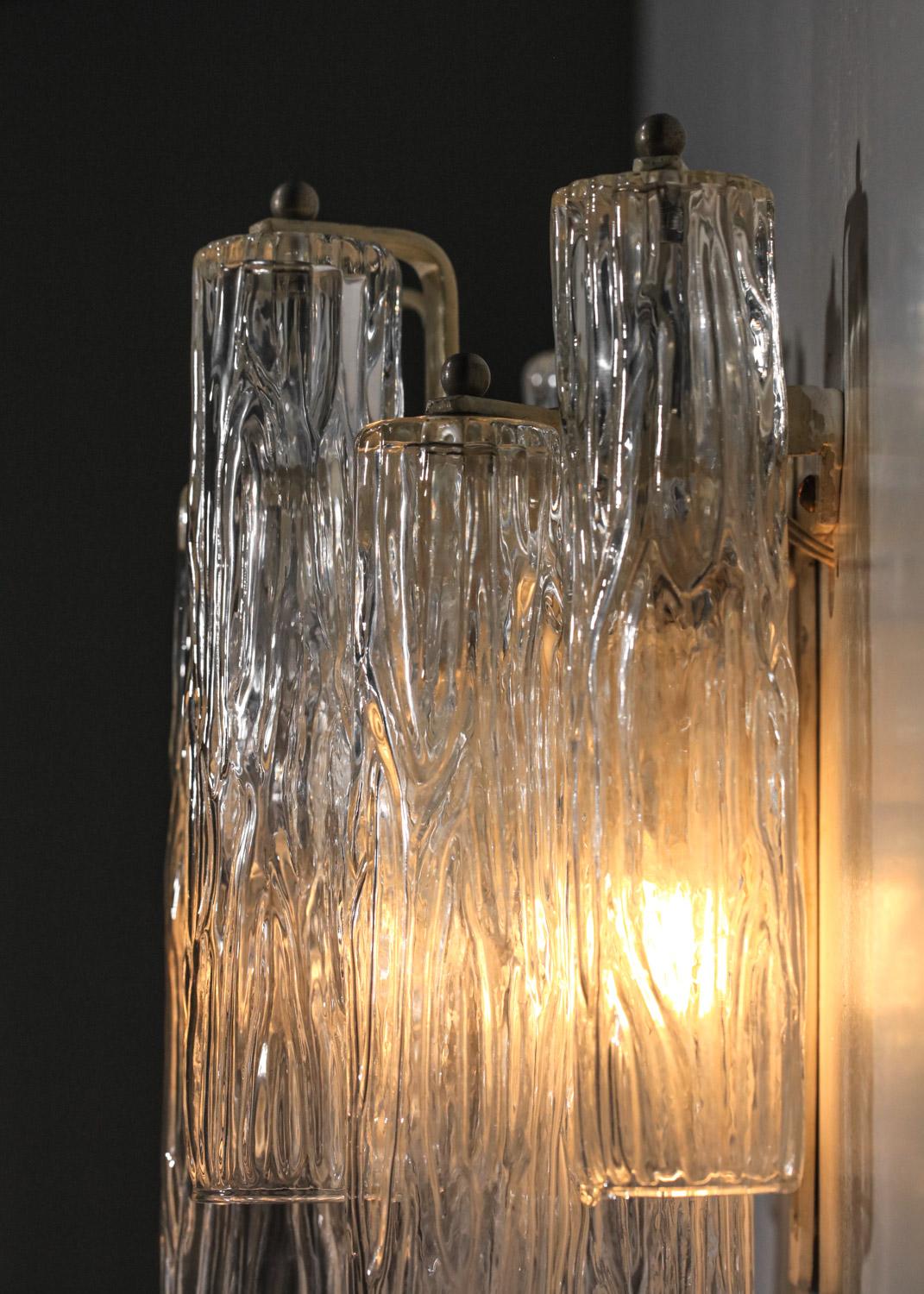 Pairs of Italian wall lights from the 70s in the style of Venini lighting fixtures of the time. White lacquered metal structure on which the different transparent Murano glass tubes hang. Very beautiful vintage condition, note slight traces of time