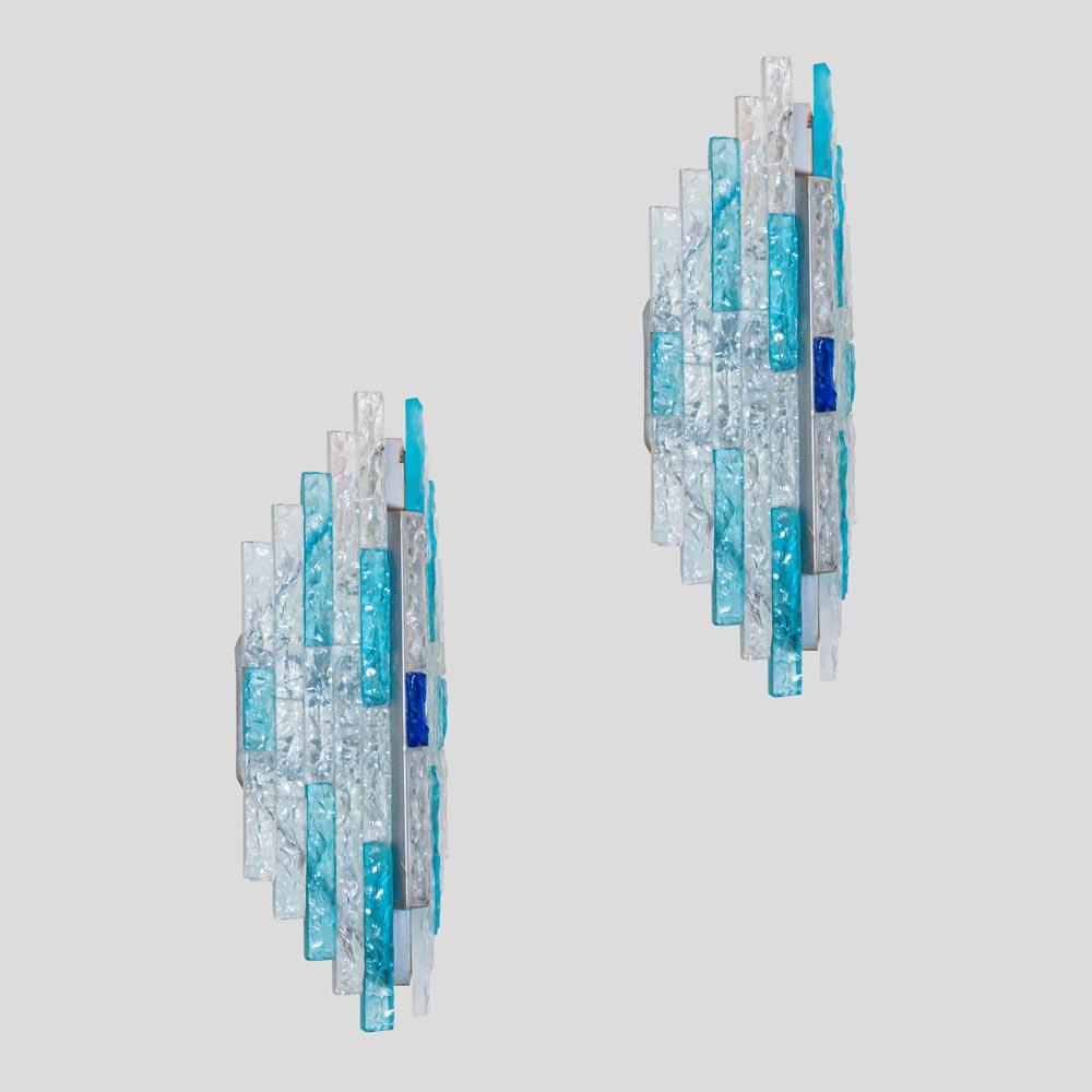 A stunning pair of Vintage 1970s sconces Frosted clear and shades of blue and aquamarine colour thick glass tassels on a patinated steel metal slightly curved asymmetrical rhomboid shaped frame. This pair of wall lights Its of a good quality design
