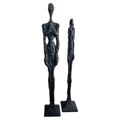 Paire de sculptures masculines de 77 pouces et féminines de 69 pouces dans le style de Giacometti