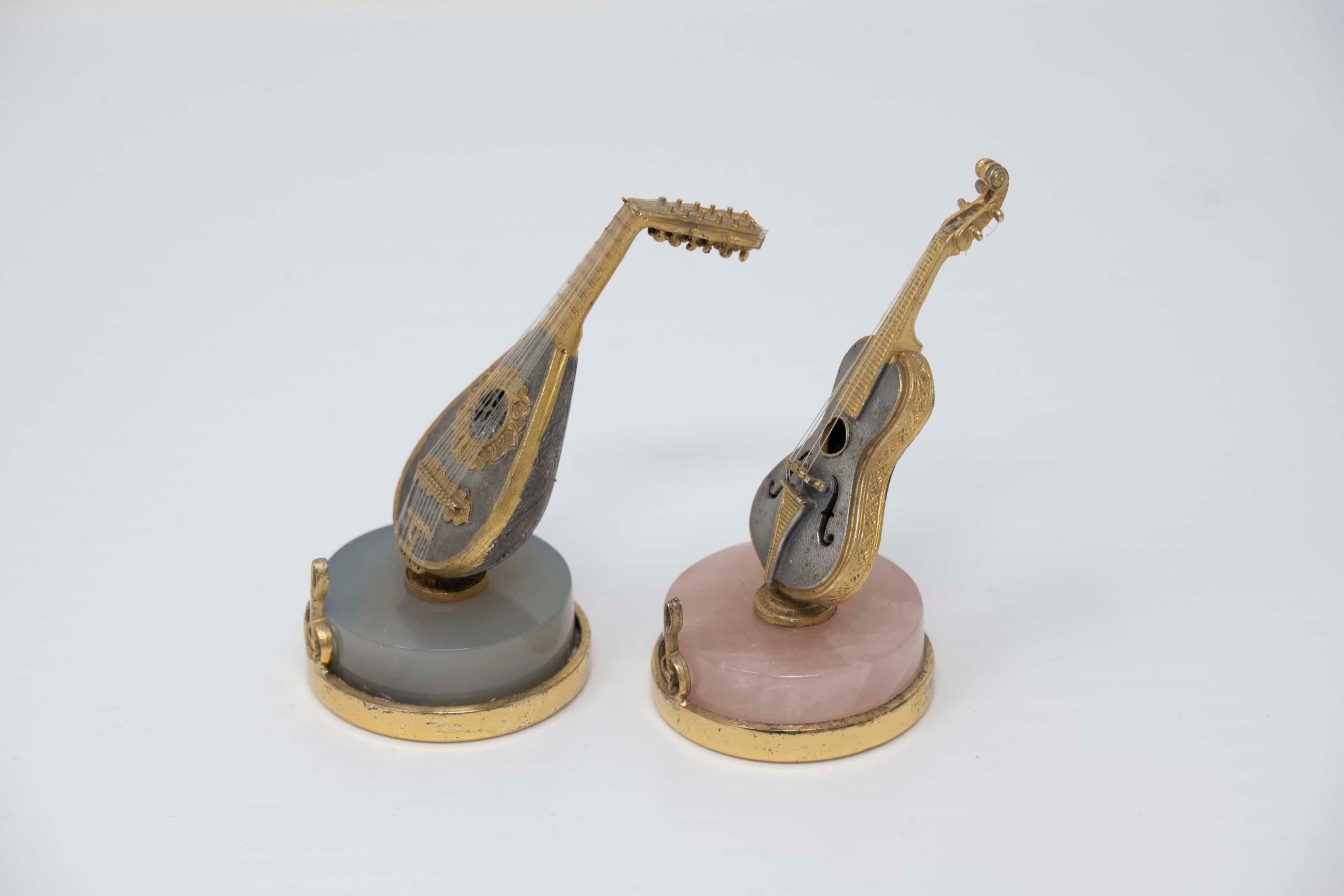 Pair of 800 silver gilt miniatures of musical instruments standing on hard stone. Stamped 800 Milano, measures 2 1/2 inches tall, in good vintage condition.
