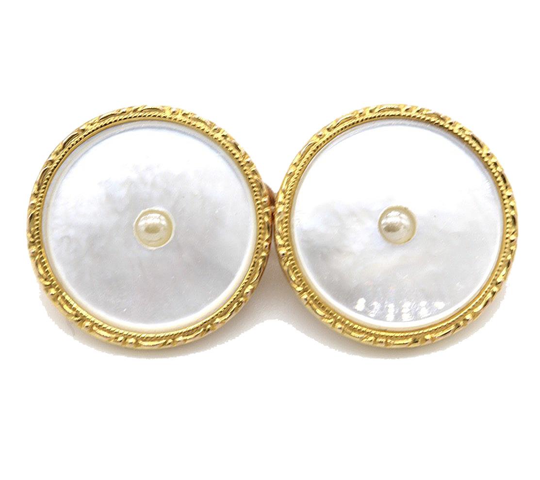 A pair of round 9 kt yellow gold rimmed mother of pearl cuff links with a central pearl, the links joined by a chain and with two matching dress studs. In original faux tortoiseshell case.
Stamped 9 kt (rim)