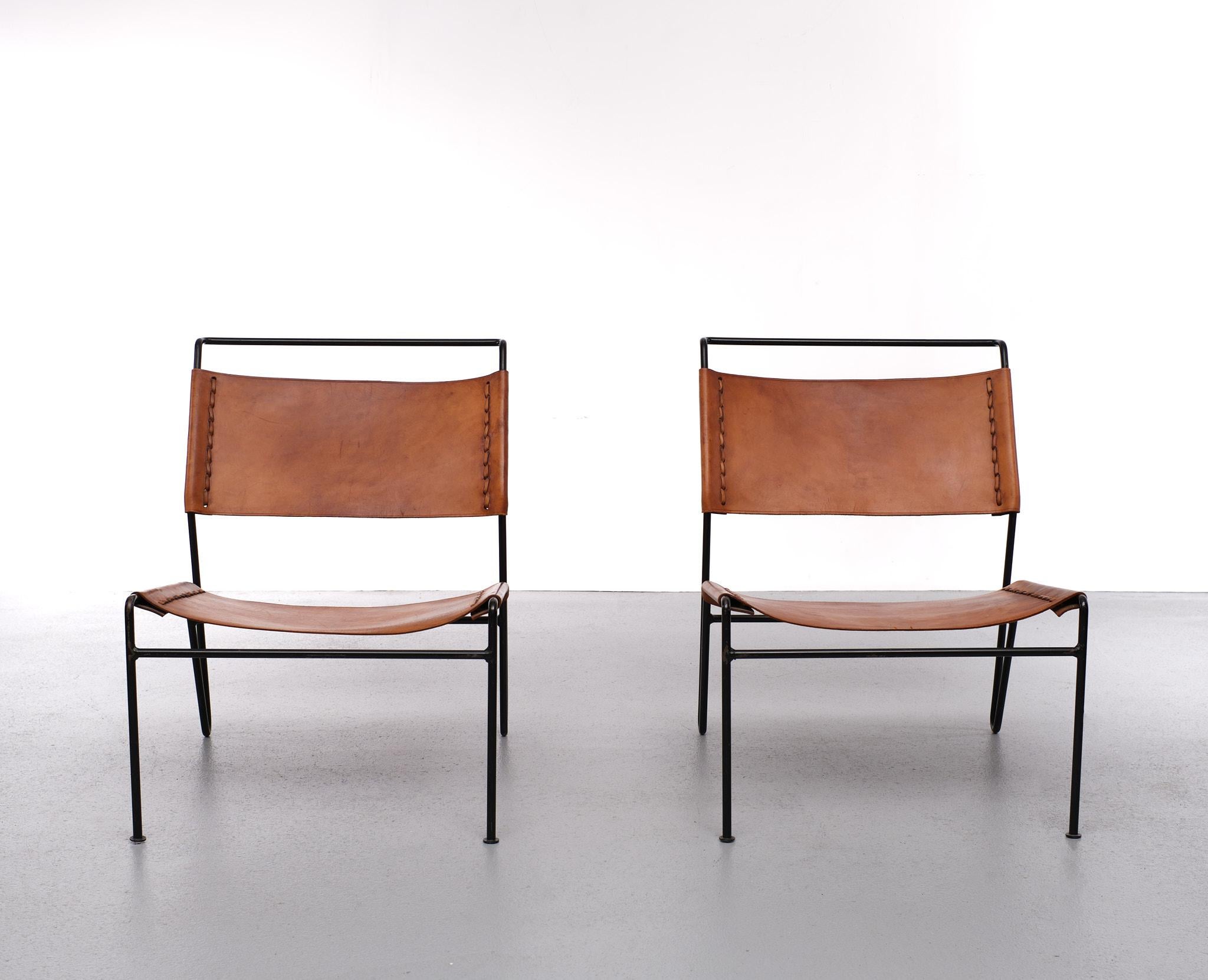 A fantastic pair of lounge chairs designed by A. Dolleman, manufactured by Metz & Co in the Netherlands around 1950. The chairs have very appealing, minimalist design. Their thin black lacquered metal bases are nicely bent in to shape. The seat and