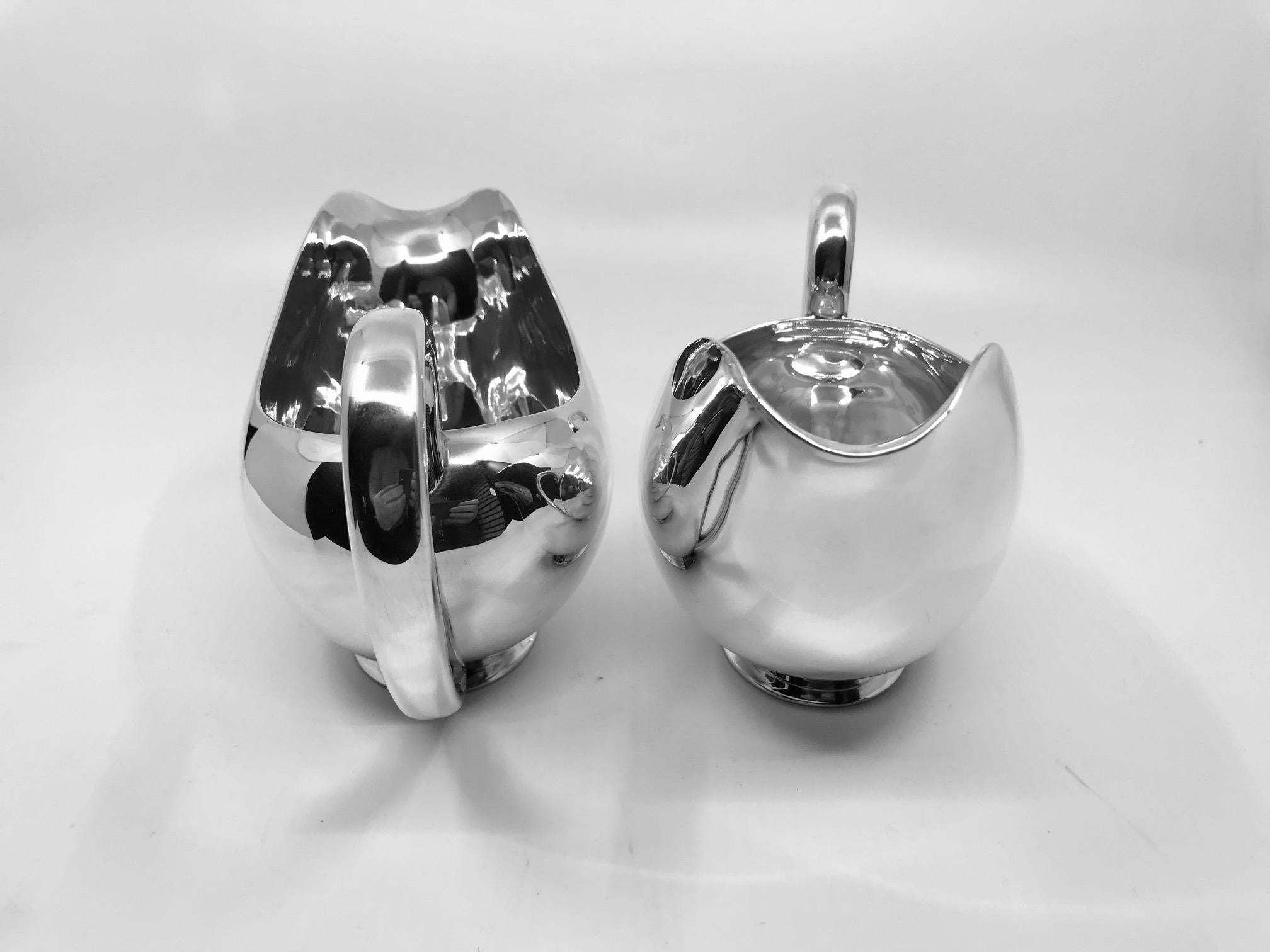 This is a pair of sterling silver sauce boats by purveyors to the Royal Danish Court Anton Michelsen, design from 1927 by Kay Fisker.

Each measures 4 1/4? in height to the top of the spout, 7½” in total length x 3 5/8? across at widest part