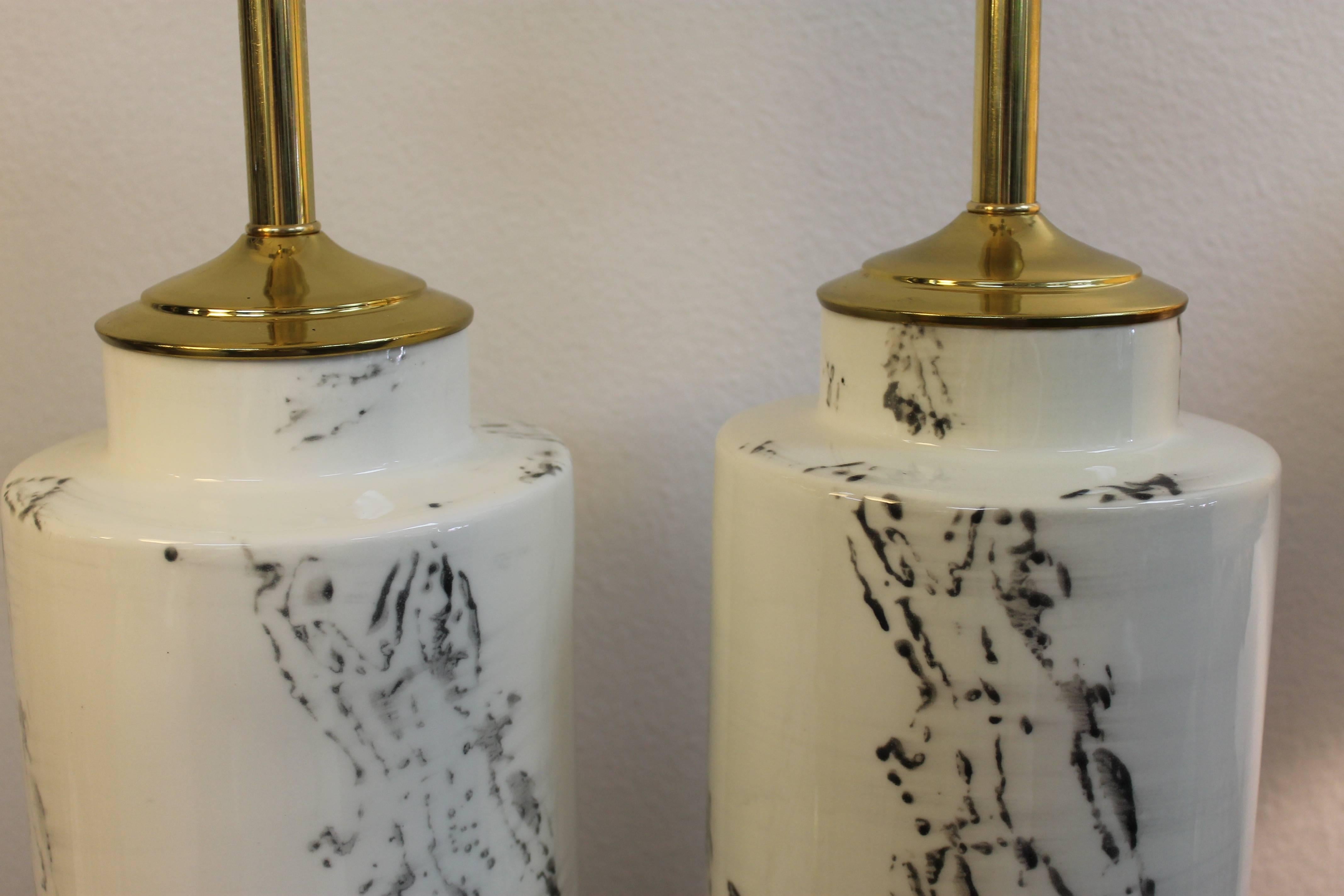 Pair of Asian inspired black and white ceramic lamps. Lamps have been professionally rewired, fitted with new brass hardware and black wood bases. Ceramic portion is 20