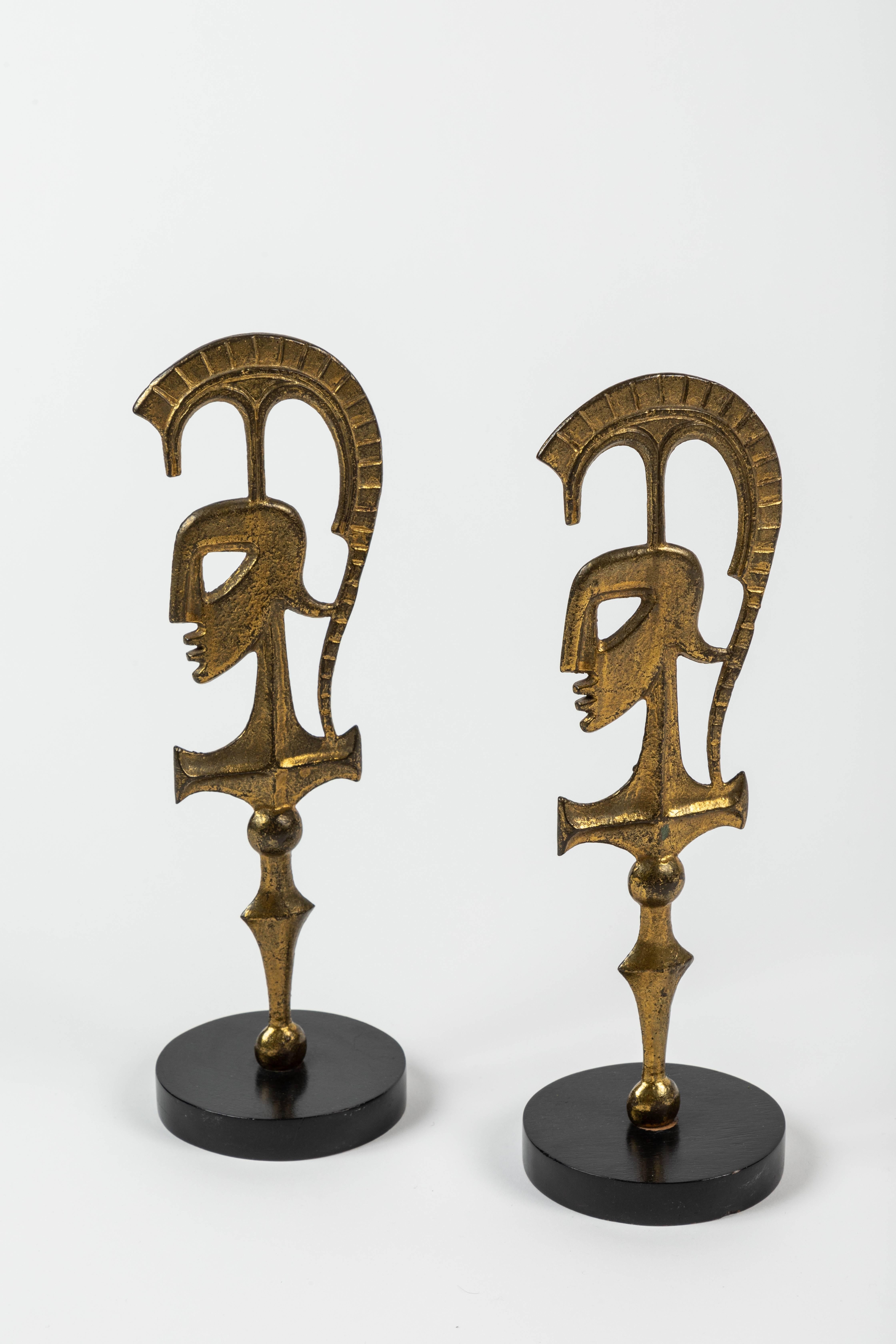 A pair of rare and iconic 'Roman Gladiators' table sculptures by Frederick Weinberg. These abstract sculptures portray a stylized profile of a Roman soldier / gladiator.

Spectacular form and design; the brass figures are mounted on a round,