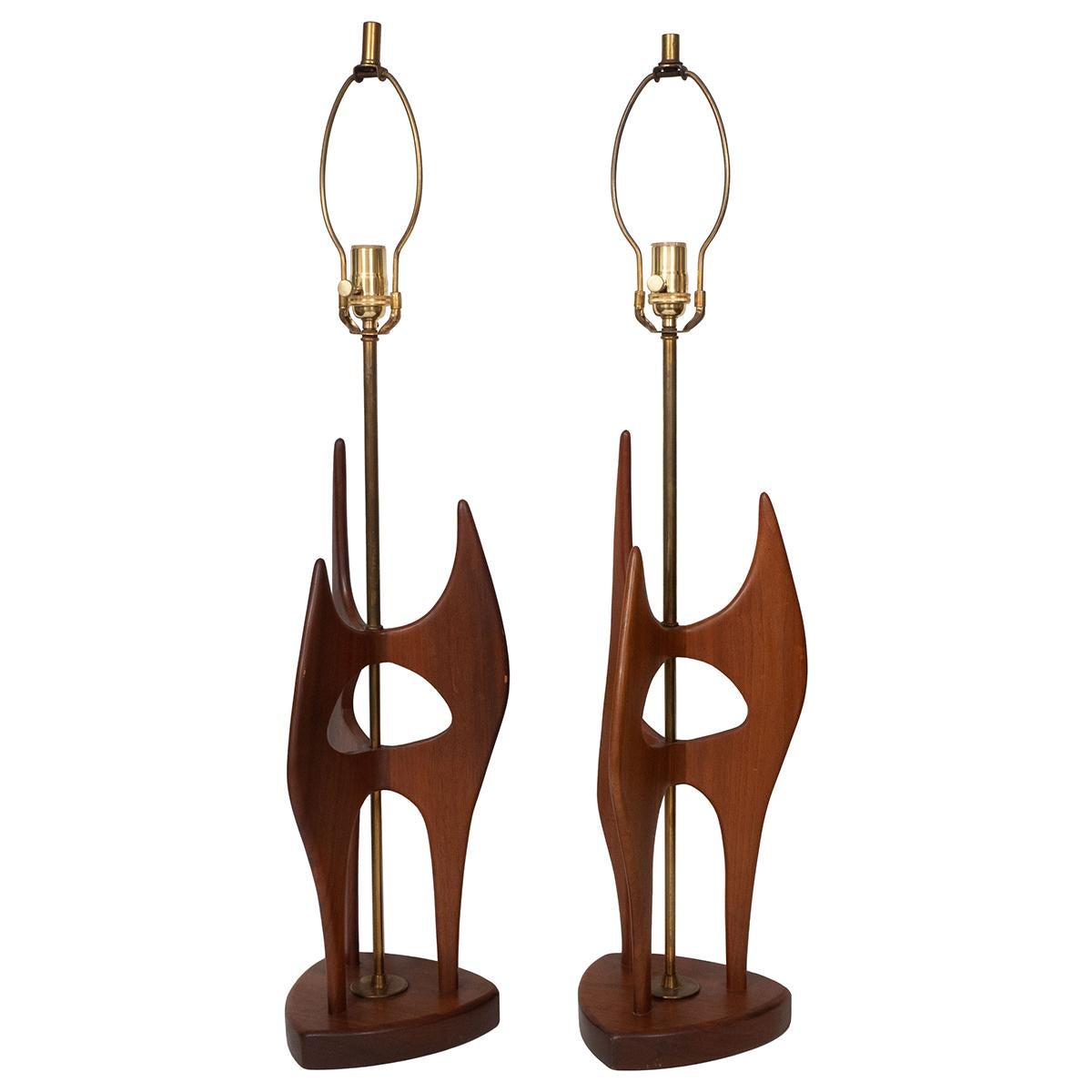 Pair of abstract, sculptural walnut wood table lamps with brass hardware. Please note color difference between the two.