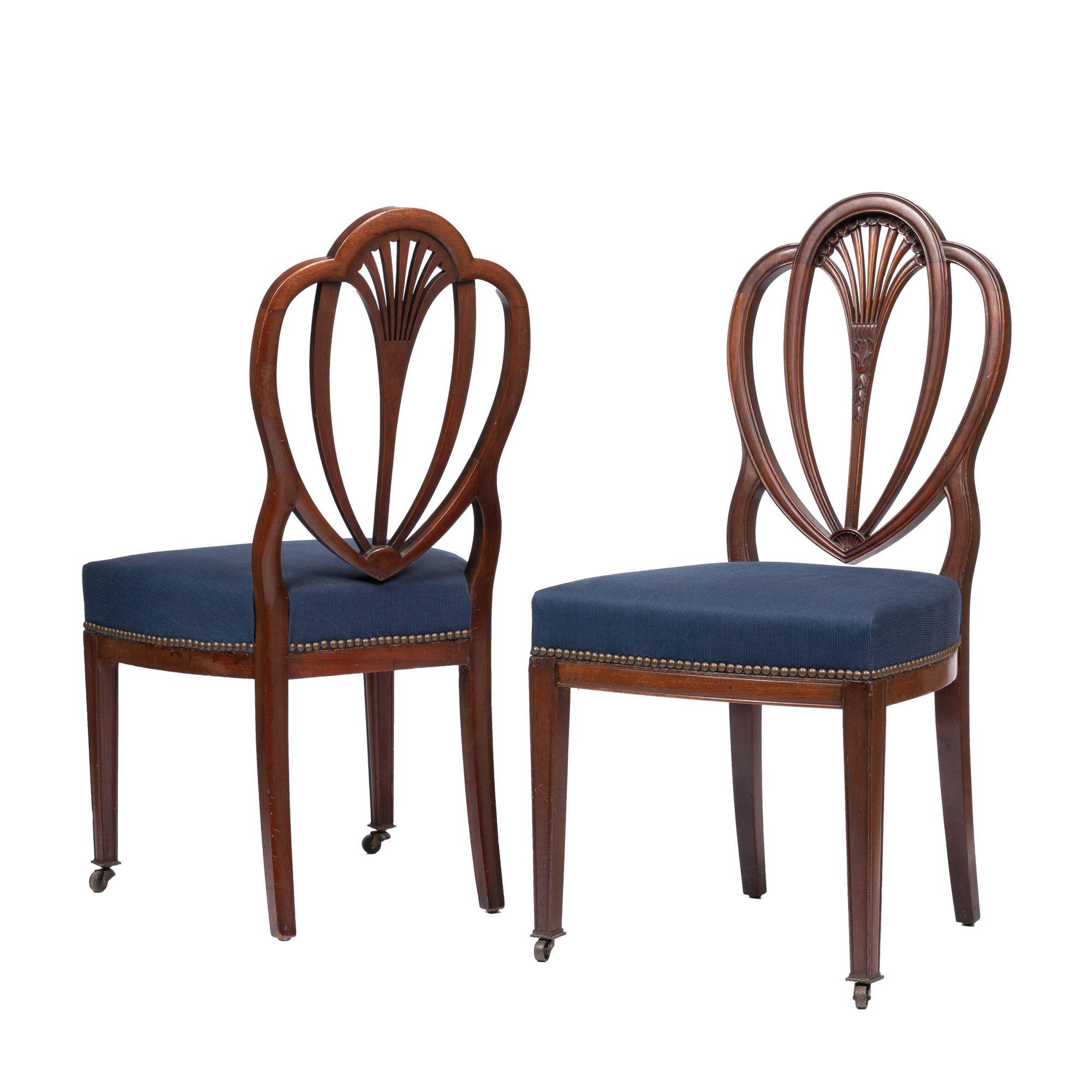 Pair of Academic Revival heart back mahogany side chairs with half rail upholstered boxed seats in indigo fabric with brass nail head tacks. The front legs are fitted with their original cast brass castors with beaded rim cup. Note: one chair is