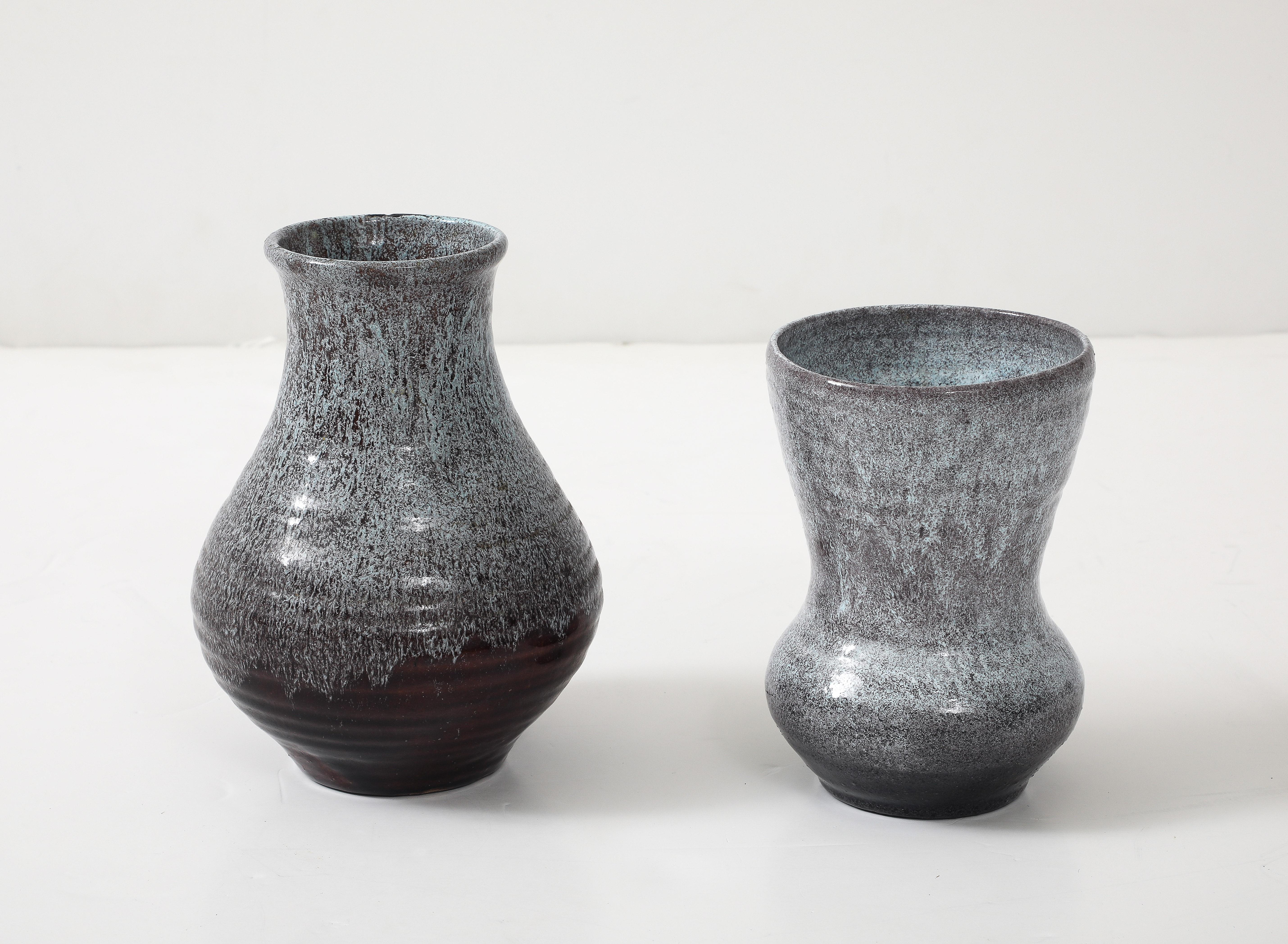 Pair of complimentary hand built speckled glazed ceramic vases ina mink brown/black and white/cream. 