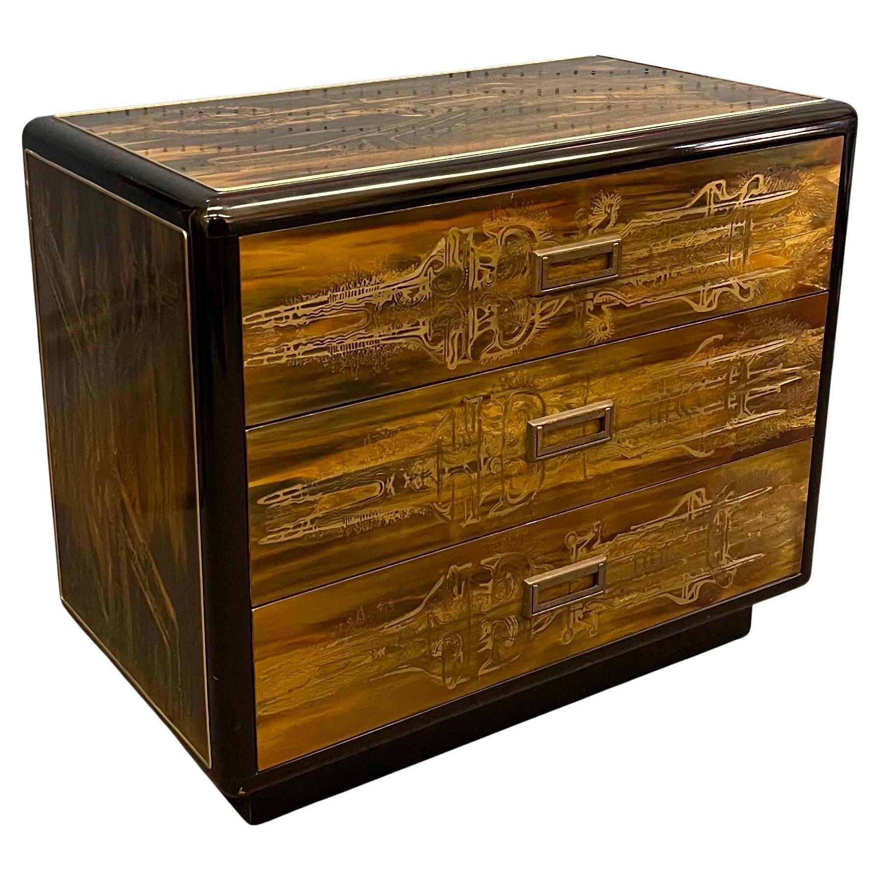 An exquisite and rare pair of acid-etched brass with ebony lacquer three drawer dressers / commodes by Bernhard Rohne for Mastercraft, circa 1970s. Covering each case are abstract designs in Rohne's signature surface treatment of acid-etched brass