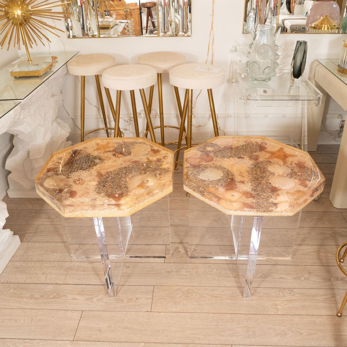 Pair of acrylic side tables with cross bases and resin encased 