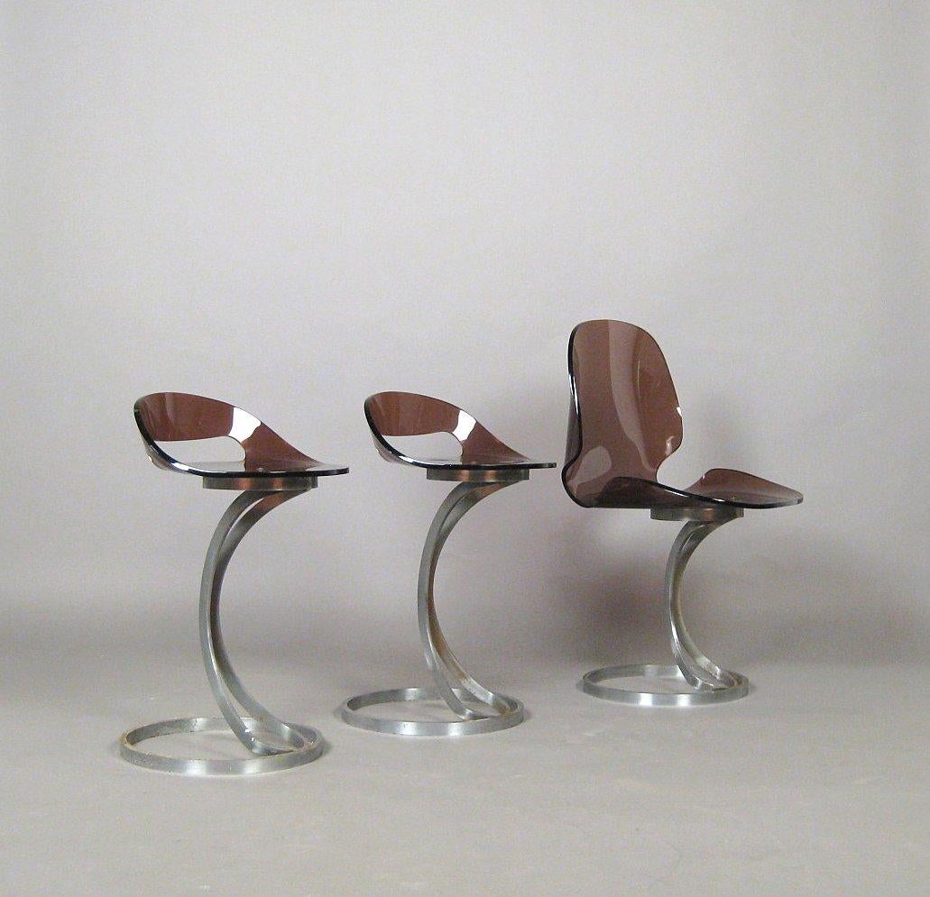 Pair of acrylic stools from the 1960s. Cantilever construction with frames made of flat steel, seat shells made of brown tinted acrylic / plexiglass. Traces of wear with age, partial scratches, some rust on the frames, the two stool frames were