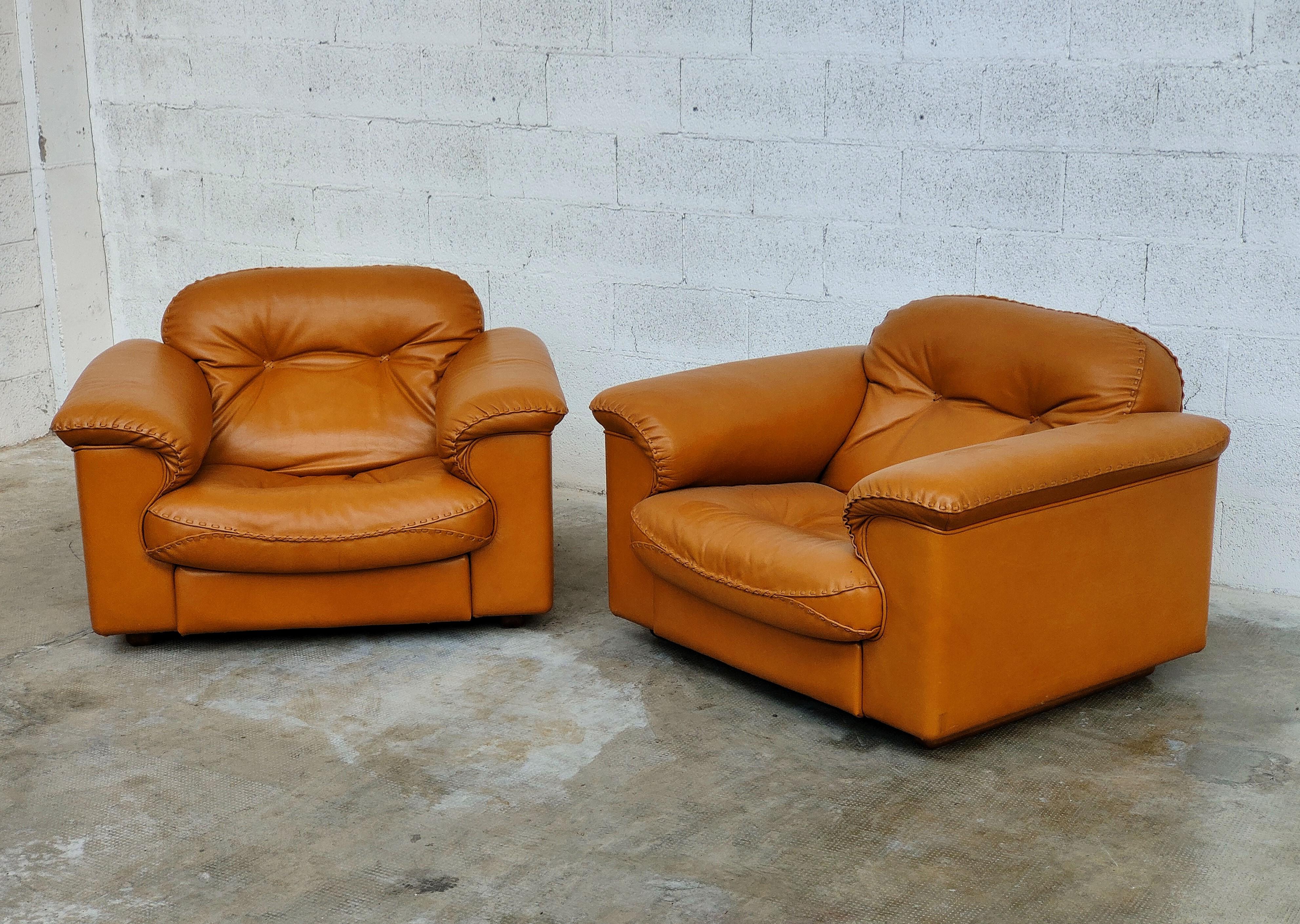 A pair of De Sede leather lounge chairs upholstered in leather, c.1970s. 
These Swiss made chairs feature a reclining mechanism that allows the seats to extend forward while the back rests recline for maximum comfort. 
The hand stitched seams add