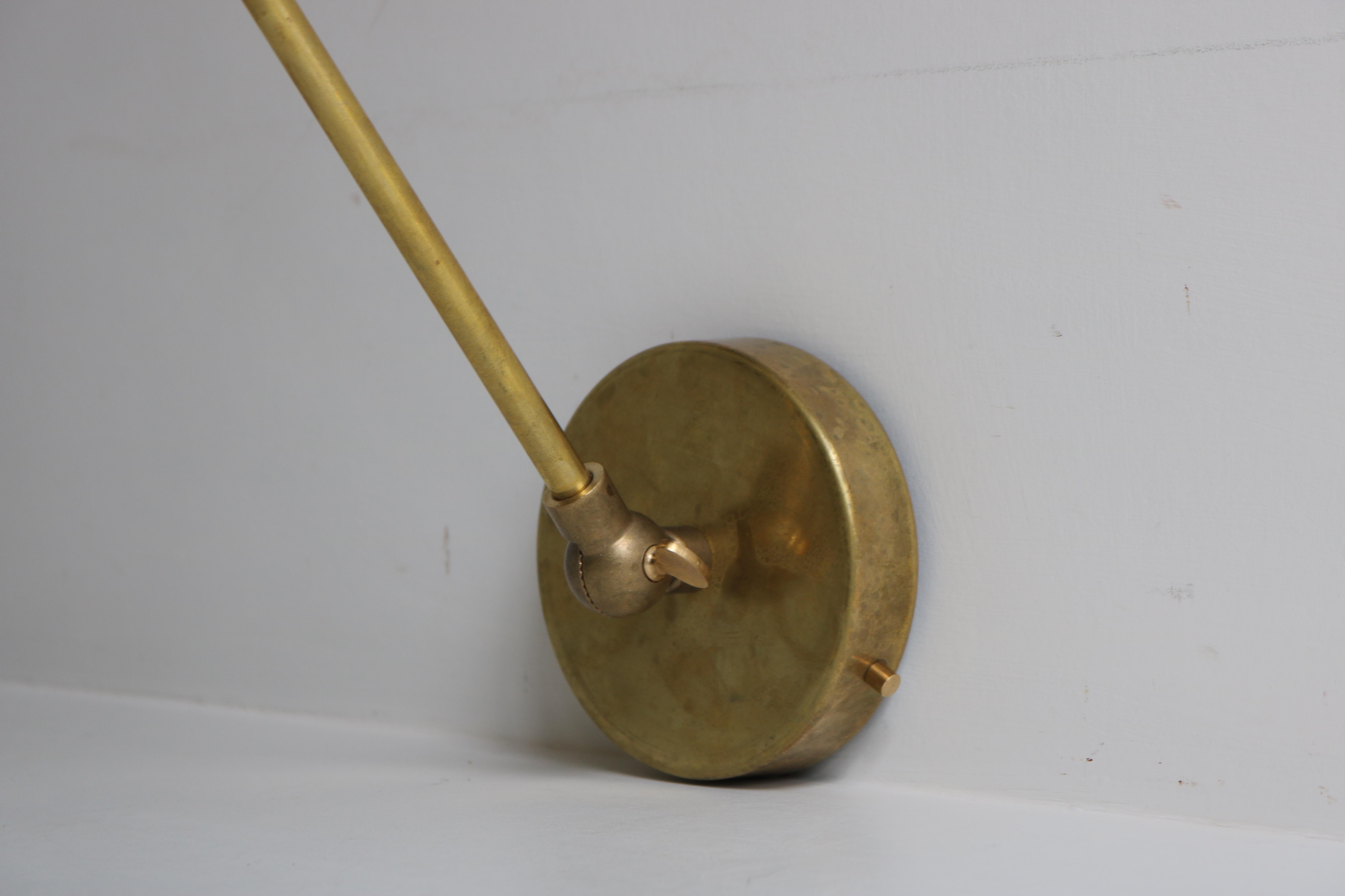 Splendida coppia di applique di design italiano degli anni '50 nello stile minimalista di Stilnovo. 
Un'incredibile combinazione con la struttura minimalista in ottone e i paralumi in metallo bianco e nero!
La posizione/forma delle luci a parete può