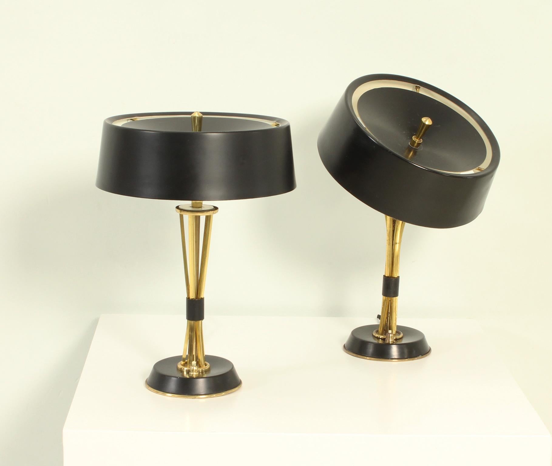 Pair of table lamps designed by Oscar Torlasco for Lumi, Italy 1960's. Adjustable shade that can take different positions. Shade and base in black lacquered aluminum and brass stem and details. They are the medium model.