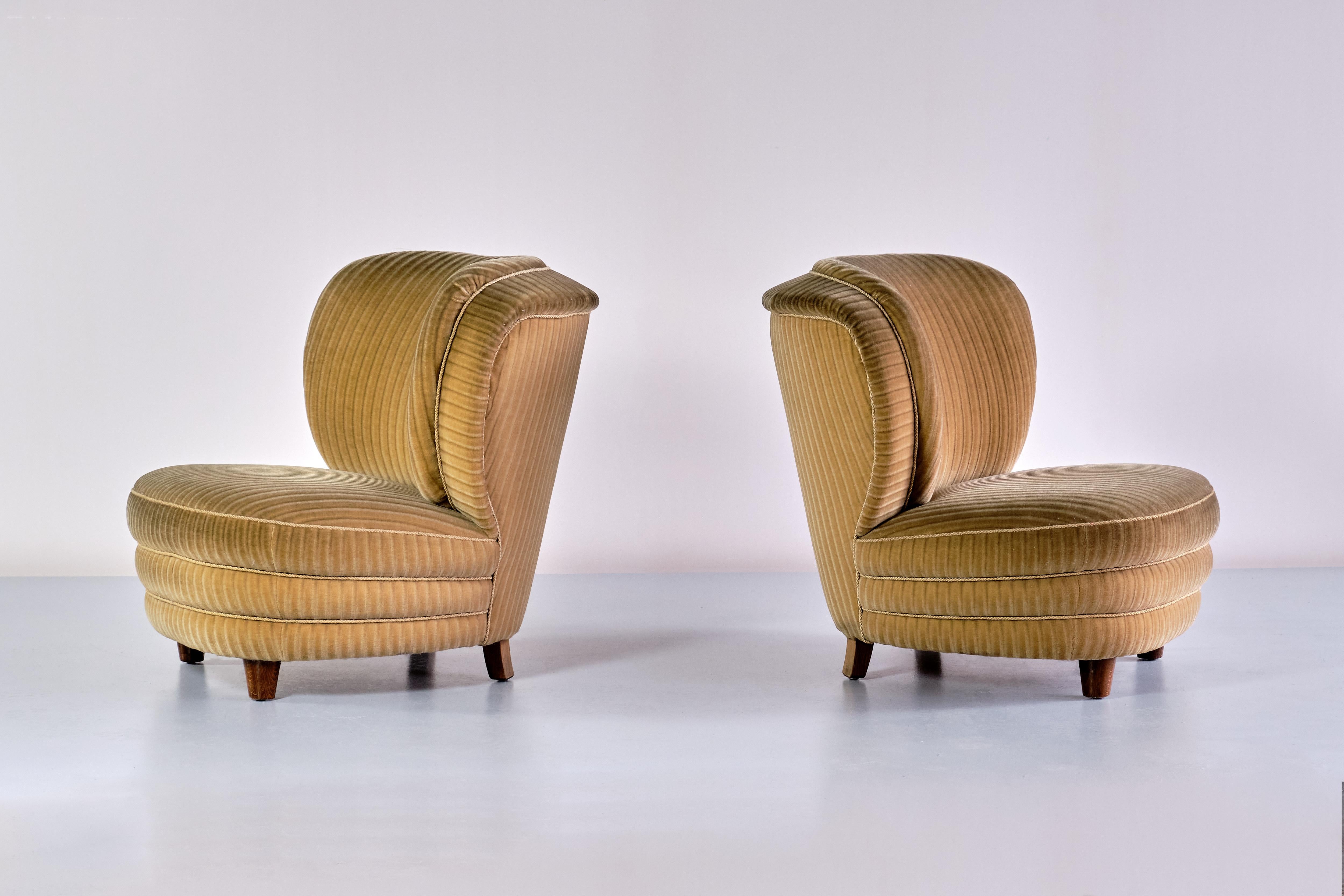 This pair of lounge chairs was designed by Adolf Wrenger and produced by his company in Lippe, Germany in the early 1950s. The curved shape and the round lines of both the backrest and seat give the chairs a striking and elegant feel. The seat