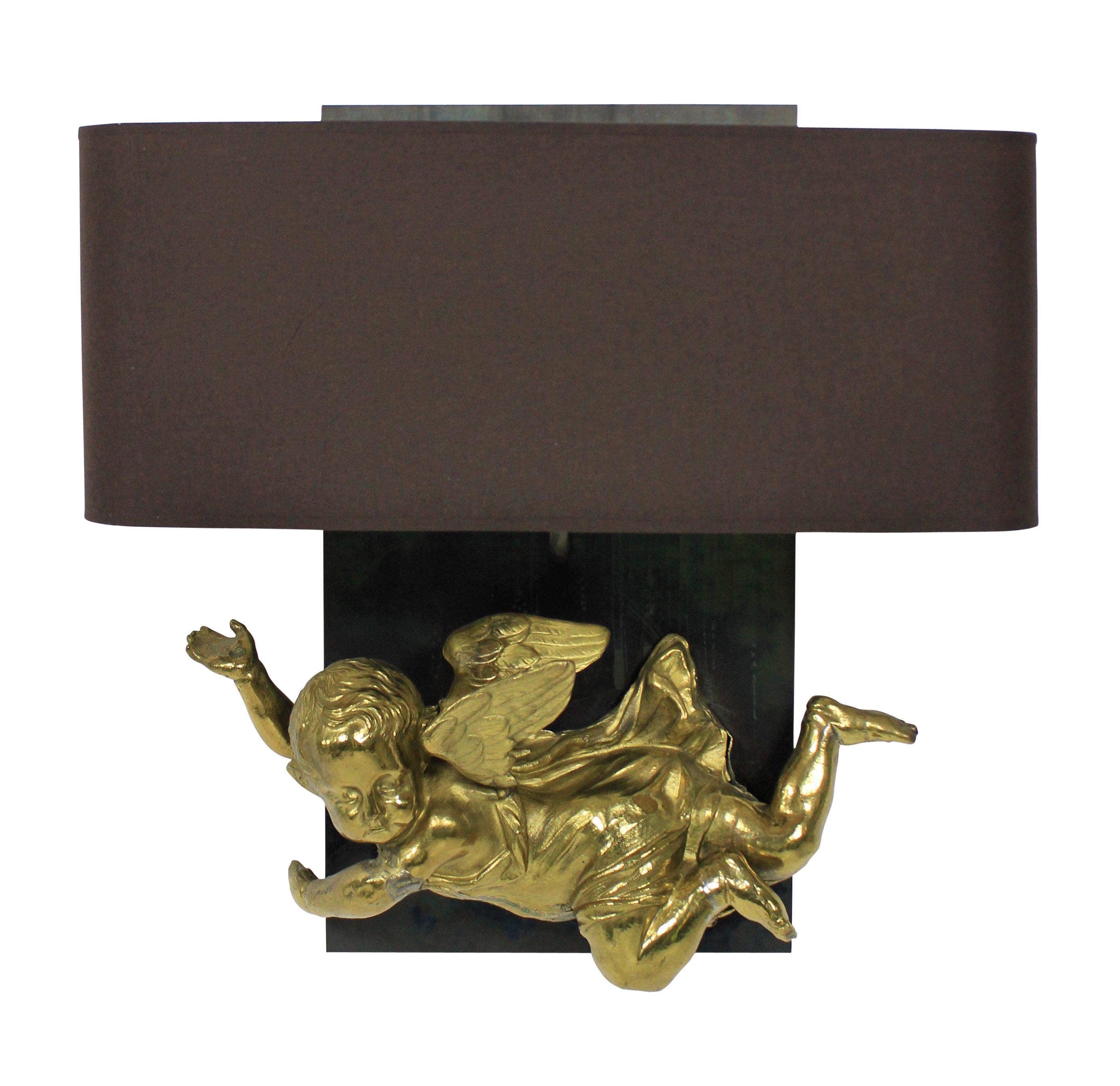 A pair of unusual French wall sconces incorporating two early 19th century gilt metal cherubs on polished steel back plates with half shades.