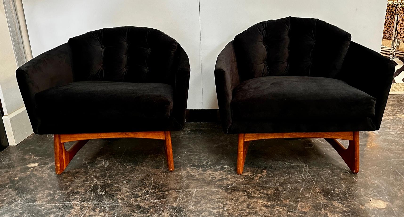 A pair of low, wide barrel chairs supported by a sculpted walnut open frame base. Made by Craft and Associates by Adrian Pearsall. The chairs have been recovered in a beautiful black velvet  and are ready to use.