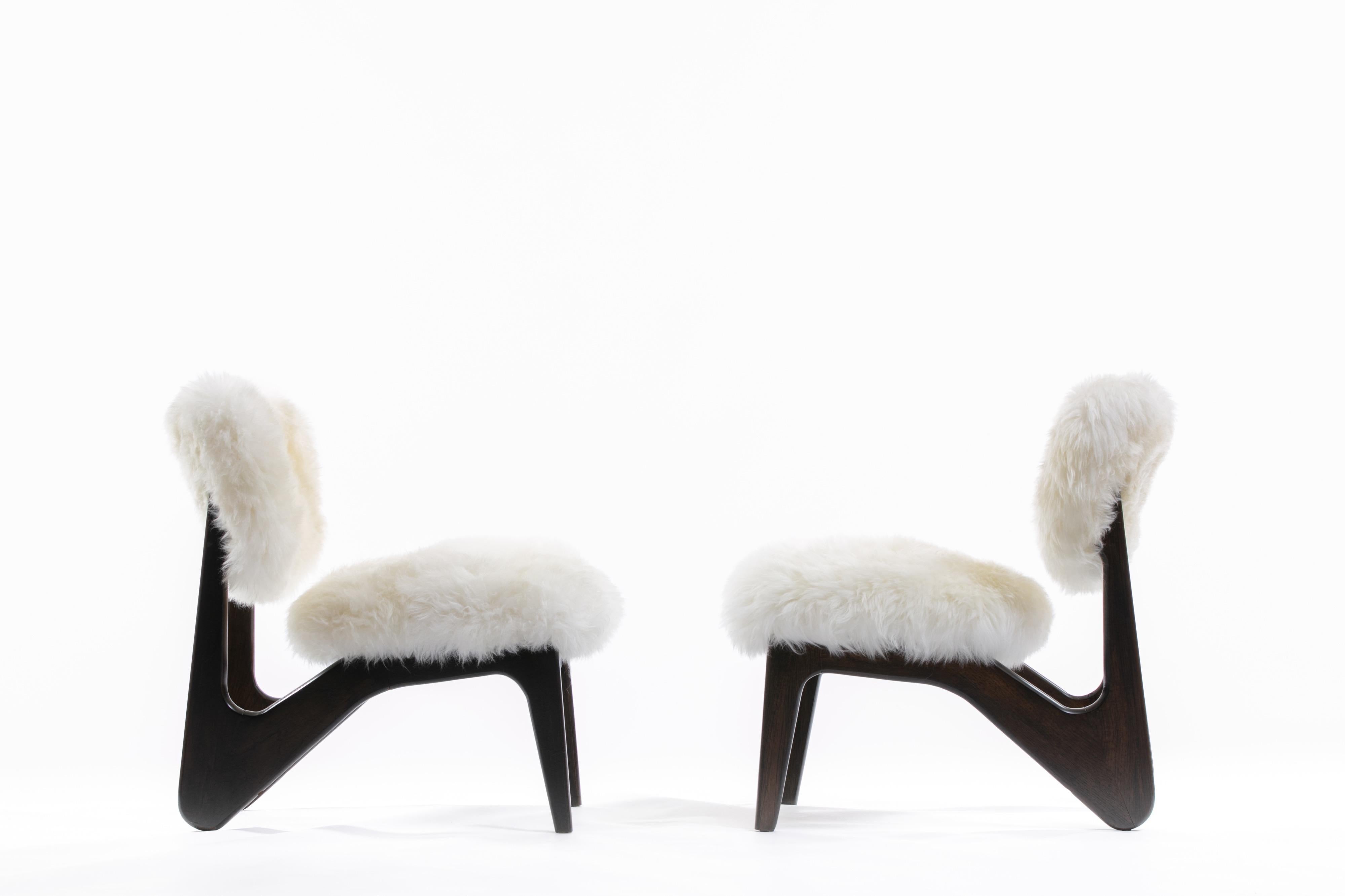 That fur, those curves! Sexy and sultry. We are enamored with these sculptural walnut slipper chairs. Newly reupholstered in lavish ivory sheepskin, the pair of chairs begs for attention and enjoyment. The walnut has been expertly refinished.