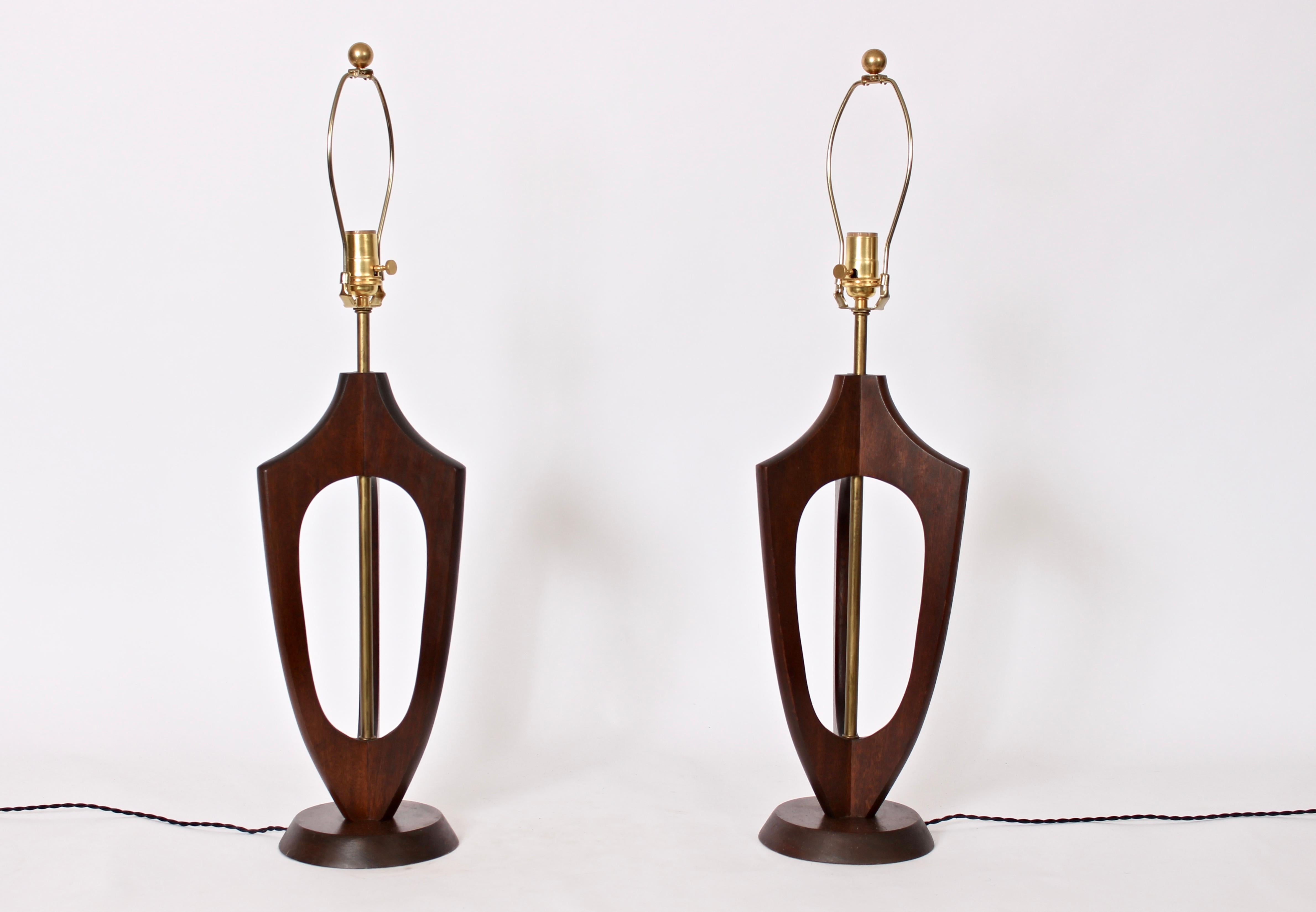 American midcentury tri form walnut and brass table lamps. Featuring a smooth three dimensional open form with three buttress arms and tubular Brass shaft. 24 to top of socket. Shades shown for display only (10H x 13 top x 15 bottom). 7D base.